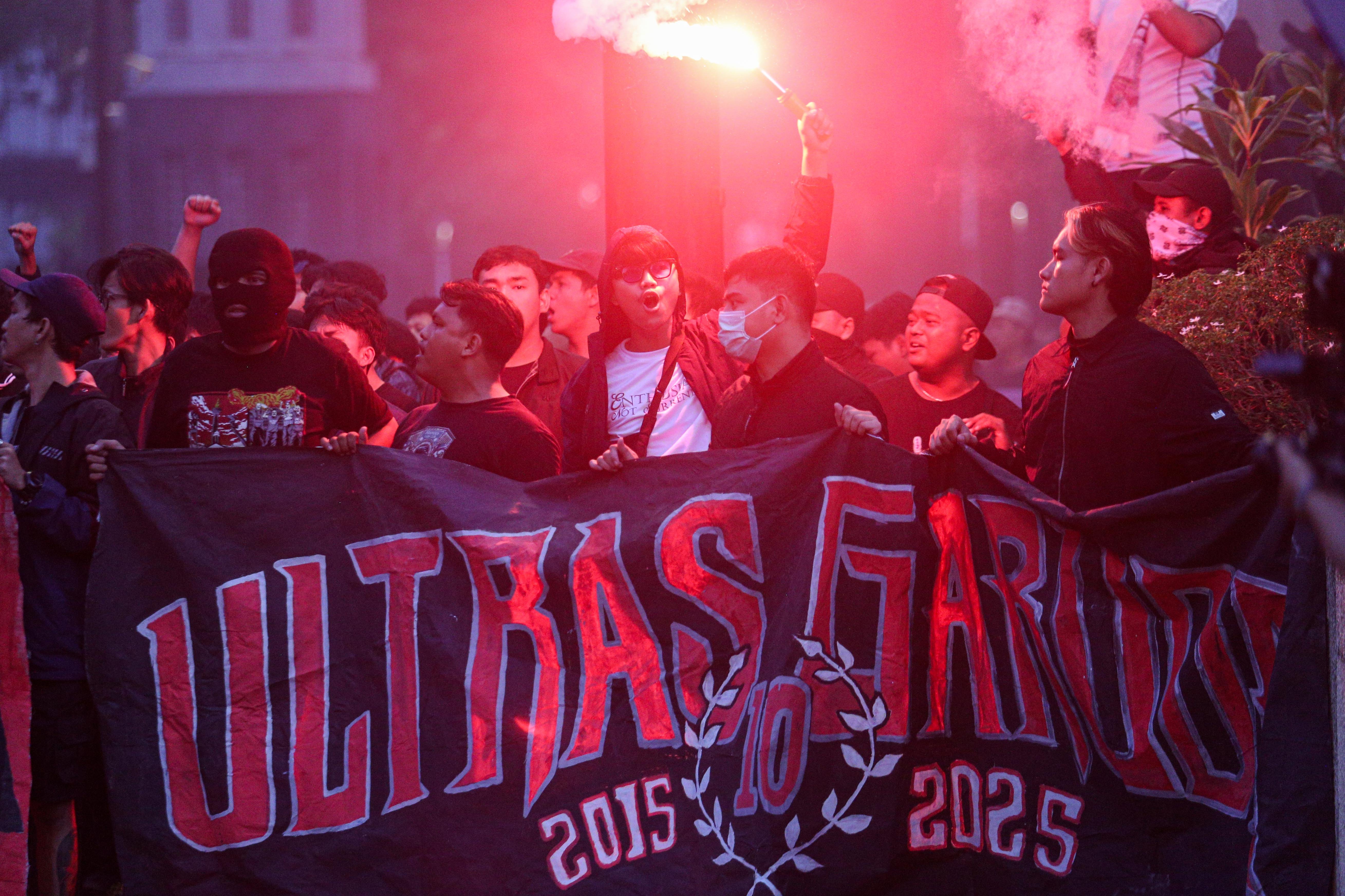 Suporter menyalakan suar dan meneriakkan yel-yel jelang laga Timnas Indonesia melawan Bahrain di luar area Stadion Utama Gelora Bung Karno, Senayan, Jakarta, Selasa (25/3/2025). Dukungan tersebut ditujukan bagi Timnas Indonesia yang akan berlaga kontra Bahrain dalam putaran ketiga Kualifikasi Piala Dunia 2026 Zona Asia.