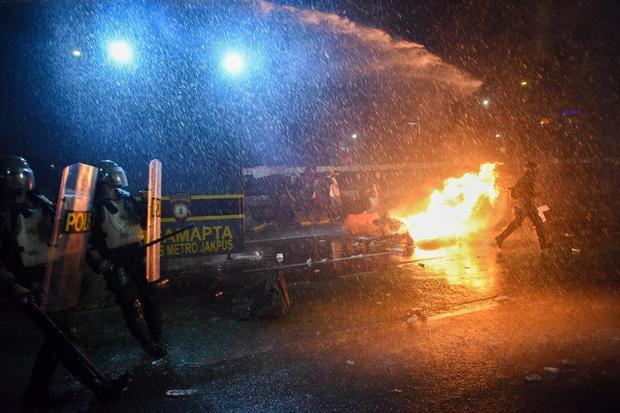 Mobil taktis polisi menyemprotkan water canon saat membubarkan pengunjuk rasa dalam aksi terkait revisi UU TNI di depan Gedung DPR, Jakarta, Kamis (27/3/2025).