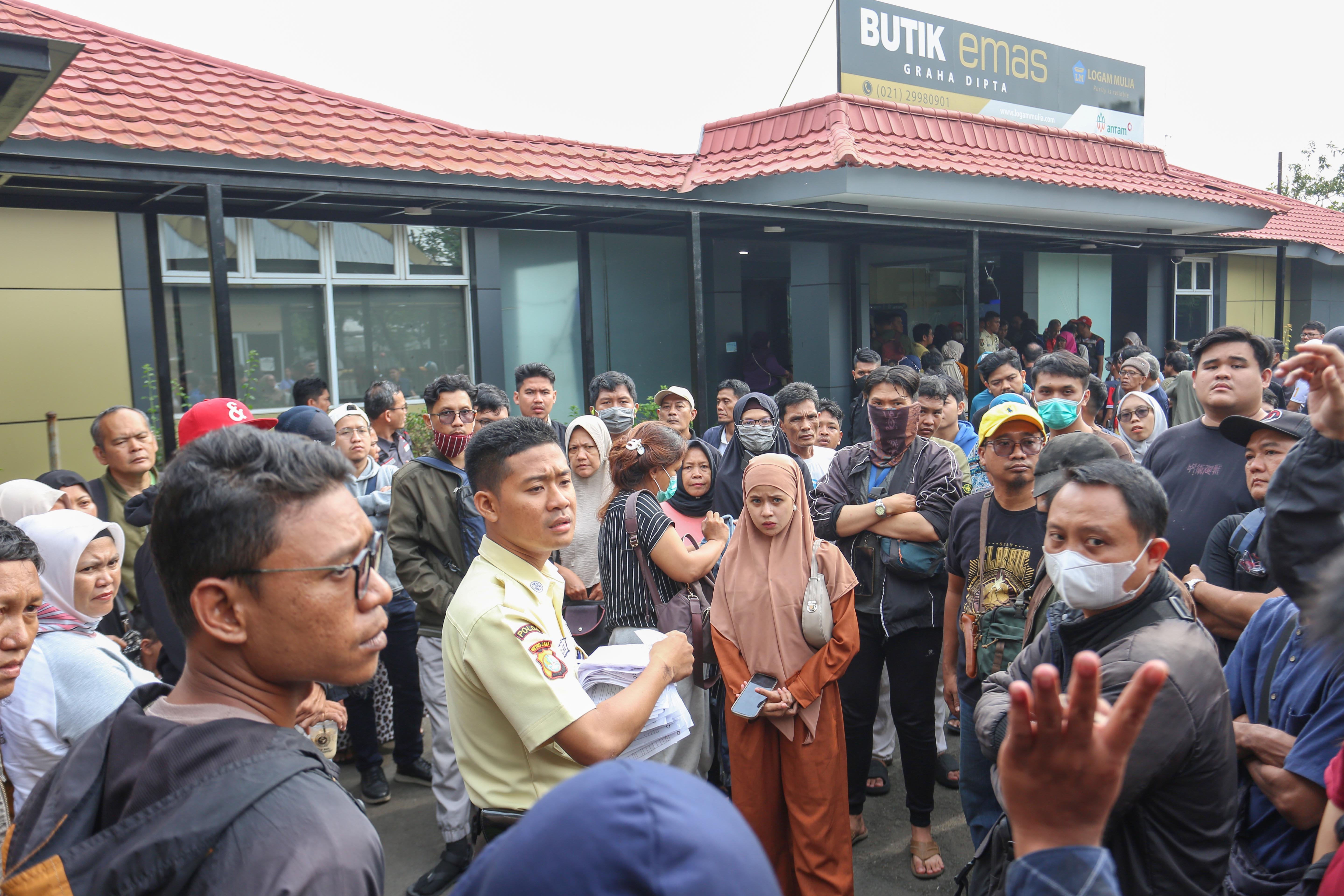 Petugas membagikan nomor antrean kepada warga yang akan memesan emas Antam di Butik Emas Logam Mulia Antam Pulogadung, Jakarta Timur, Selasa (15/4/2025). Berdasarkan laman logam mulia Antam, harga emas batangan Antam pada hari ini terpantau stagnan atau tidak mengalami perubahan yaitu sebesar Rp1.896.000 per gram, dari sebelumnya pada Sabtu (12/4) sempat berada di harga tertinggi yakni di angka Rp1.904.000 per gram.