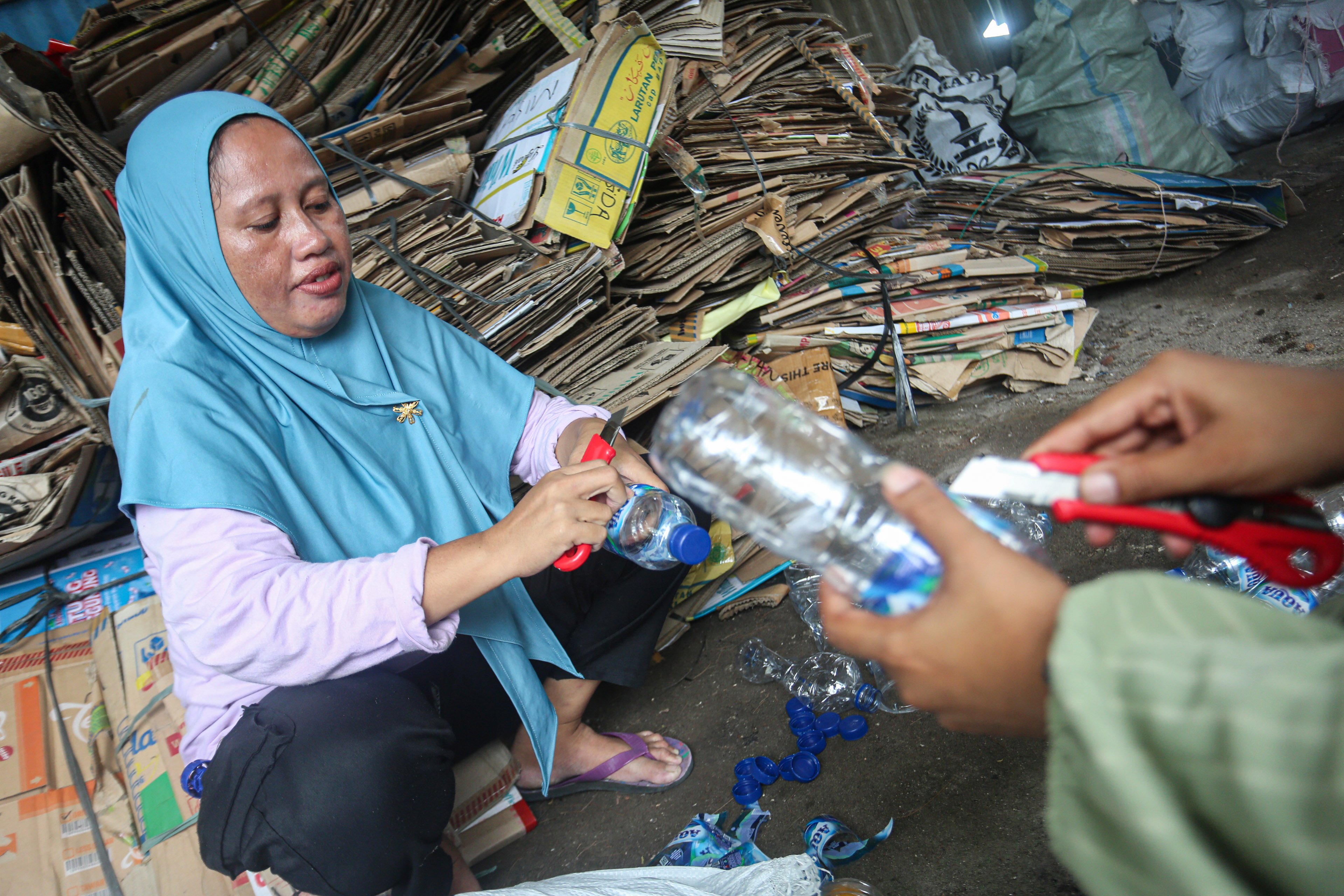 Anggota bank sampah membersihkan botol plastik yang telah dikumpulkan di Bank Sampah Kelapa Dua Indah, Pulau Kelapa Dua, Kepulauan Seribu, Jakarta, Kamis (24/4/2025). Bank sampah yang telah beroperasi sejak tahun 2019 ini mampu berkontribusi dalam meningkatkan kesadaran dan partisipasi warga dalam pengelolaan sampah di pulau tersebut dan juga menjadi sumber pemasukan tambahan bagi warga melalui sampah yang disetorkan ke bank sampah. 