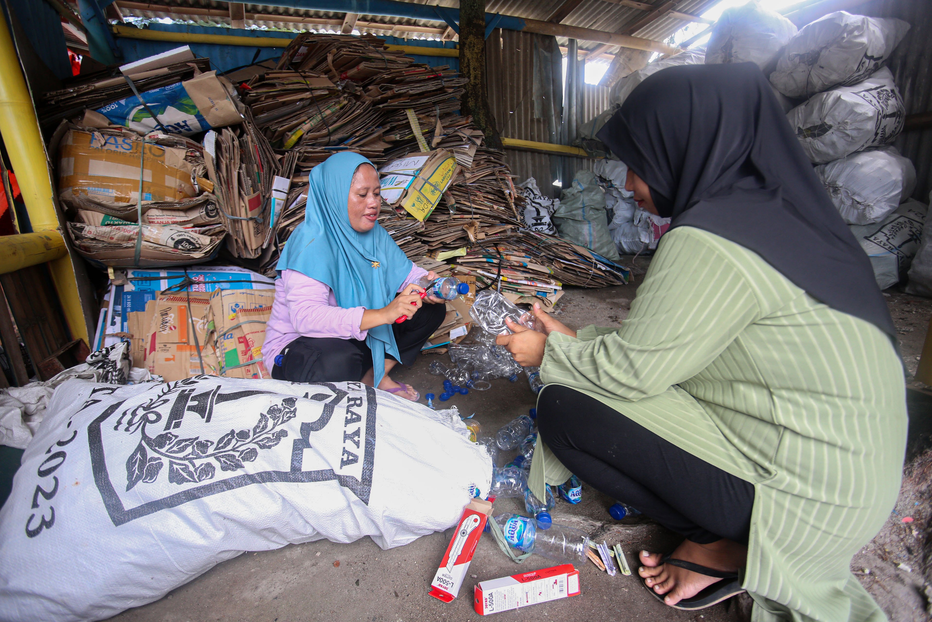 Anggota bank sampah membersihkan botol plastik yang telah dikumpulkan di Bank Sampah Kelapa Dua Indah, Pulau Kelapa Dua, Kepulauan Seribu, Jakarta, Kamis (24/4/2025). Bank sampah yang telah beroperasi sejak tahun 2019 ini mampu berkontribusi dalam meningkatkan kesadaran dan partisipasi warga dalam pengelolaan sampah di pulau tersebut dan juga menjadi sumber pemasukan tambahan bagi warga melalui sampah yang disetorkan ke bank sampah. 