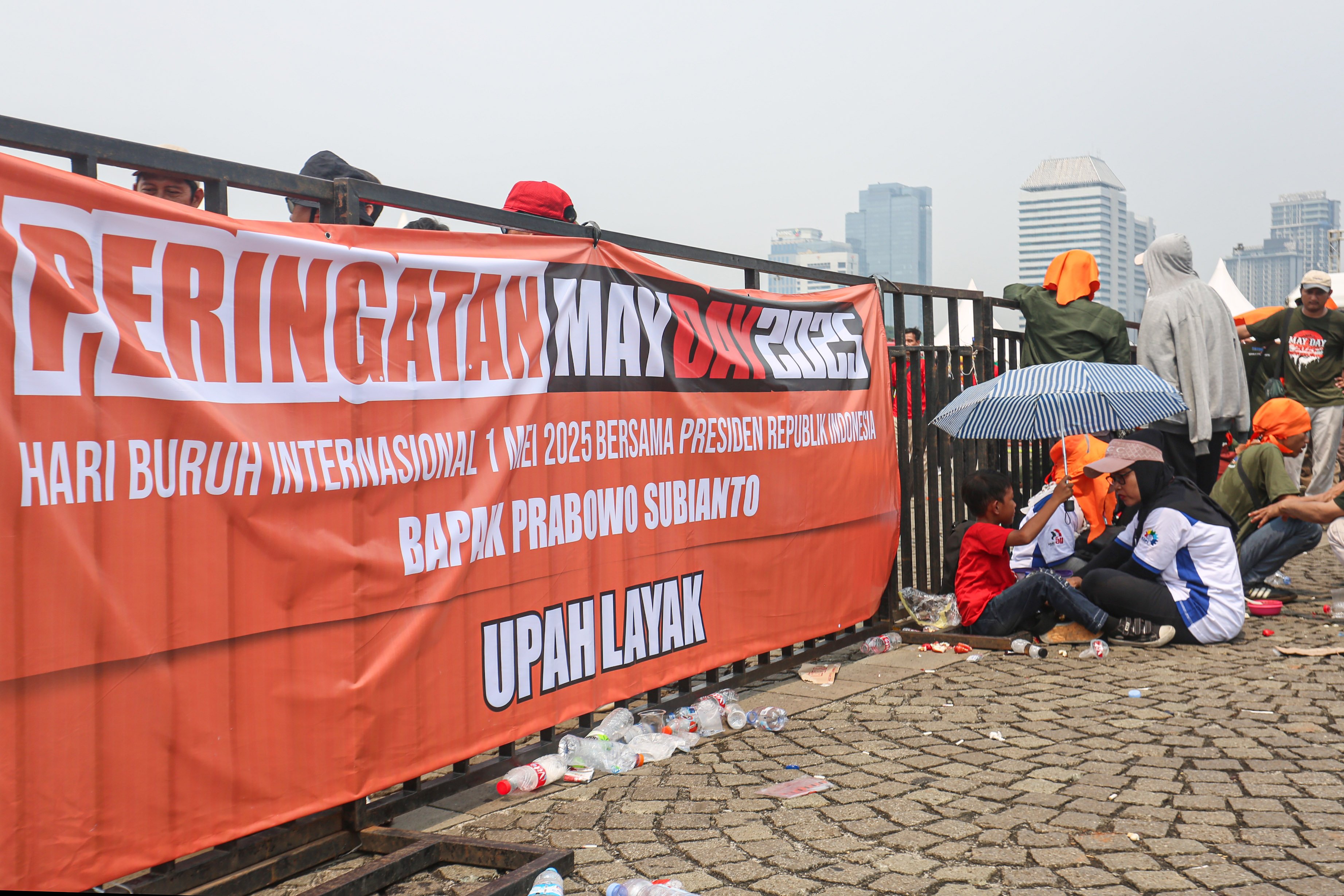 Buruh beristirahat saat mengikuti acara peringatan Hari Buruh Internasional di kawasan Monumen Nasional (Monas), Jakarta, Kamis (1/5/2025). Pada momentum tersebut mereka menyampaikan sejumlah tuntutan kepada pemerintah diantaranya yakni penghapusan sistem outsourcing, pemberian upah layak dan pengesahan Revisi Undang-Undang (RUU) Ketenagakerjaan.