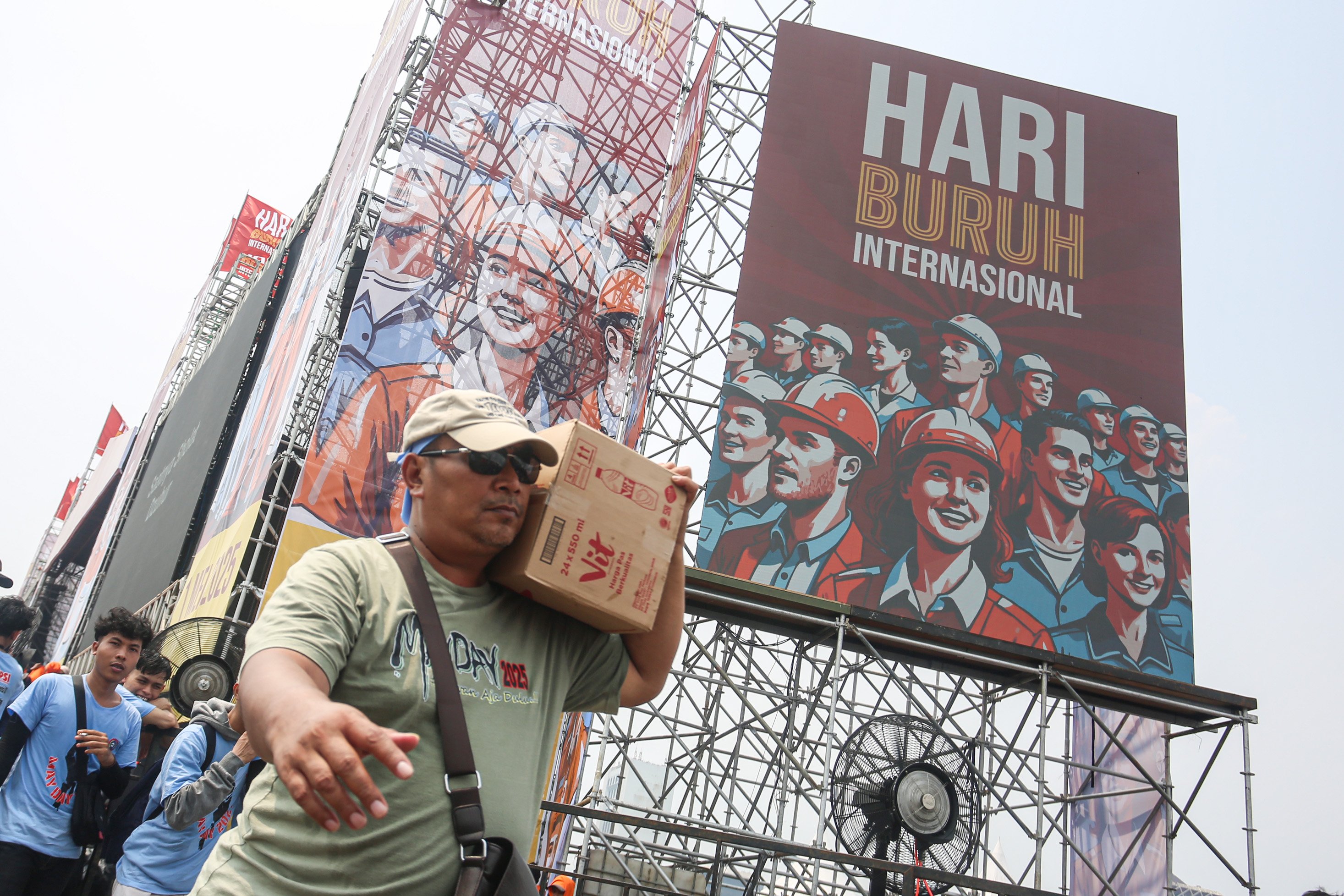 Buruh membawa kardus air mineral saat mengikuti acara peringatan Hari Buruh Internasional di kawasan Monumen Nasional (Monas), Jakarta, Kamis (1/5/2025). Pada momentum tersebut mereka menyampaikan sejumlah tuntutan kepada pemerintah diantaranya yakni penghapusan sistem outsourcing, pemberian upah layak dan pengesahan Revisi Undang-Undang (RUU) Ketenagakerjaan.