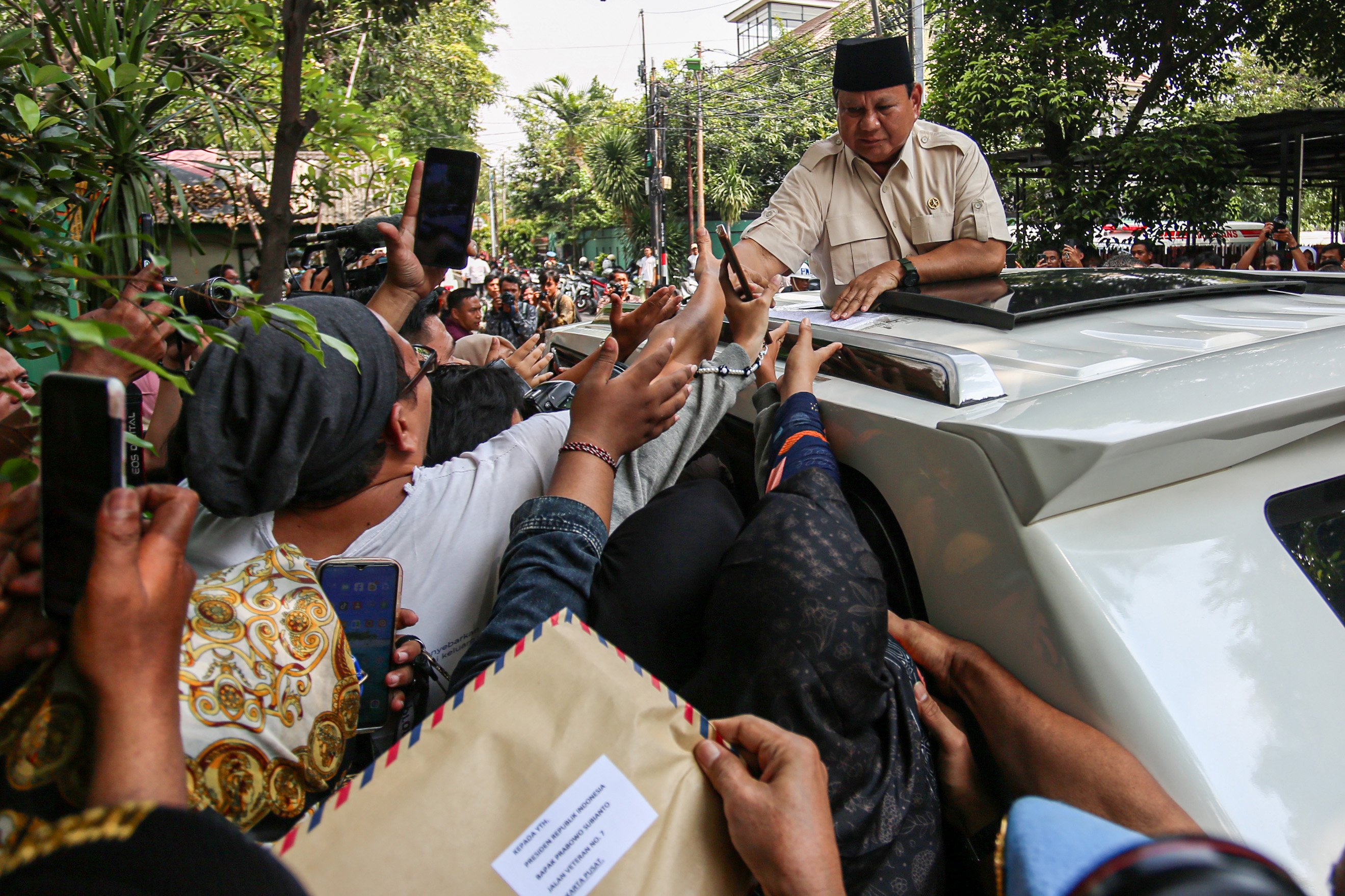 Presiden Prabowo Subianto menyapa warga seusai meninjau program Makan Bergizi Gratis (MBG) bersama pendiri Microsoft Bill Gates di SDN Jati 03, Pulogadung, Jakarta Timur, Rabu (7/5/2025). Pada kesempatan itu Presiden Prabowo Subianto dan Bill Gates turut meninjau pemeriksaan kesehatan gratis di sekolah tersebut. 