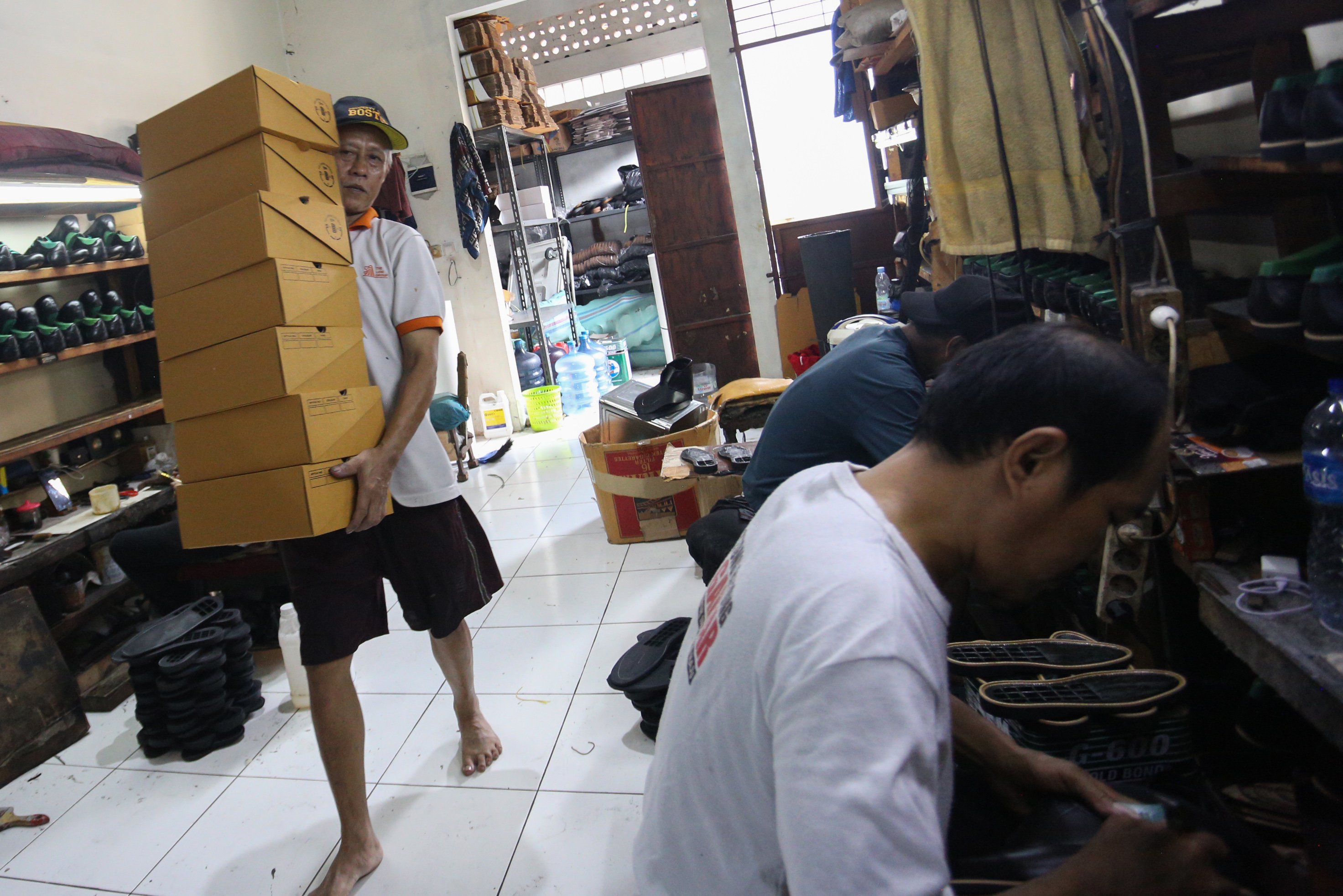 Pekerja menyelesaikan pembuatan sepatu di rumah produksi sepatu kulit Flavio & Boston, Penggilingan, Cakung, Jakarta Timur, Kamis (8/5/2025). Industri rumahan yang telah beroperasi sejak tahun 1980 ini mampu menghasilkan 1000 pasang sepatu per bulannya dengan rata-rata penjualan sebanyak 800 hingga 900 pasang sepatu.