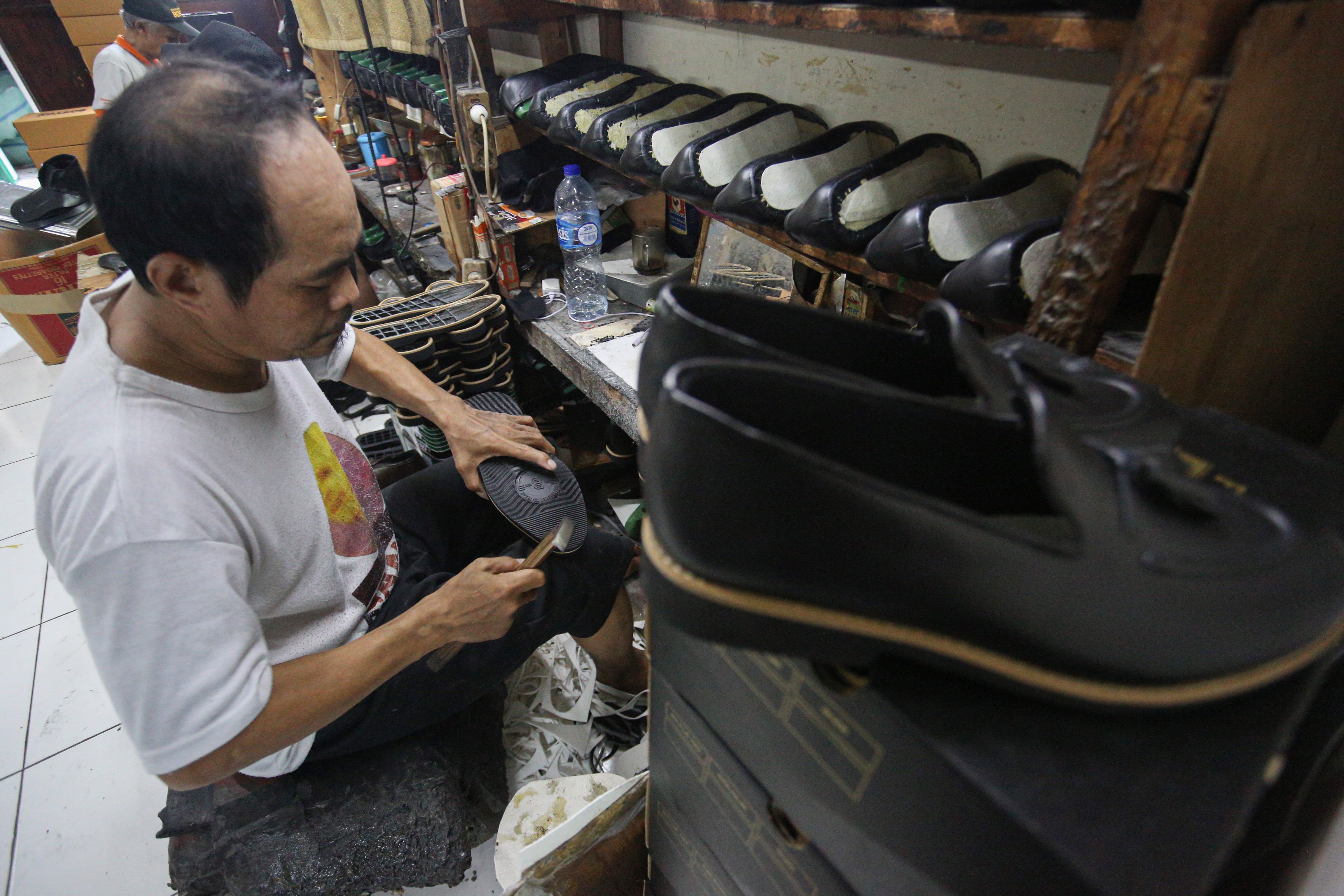 Pekerja menyelesaikan pembuatan sepatu di rumah produksi sepatu kulit Flavio & Boston, Penggilingan, Cakung, Jakarta Timur, Kamis (8/5/2025). Industri rumahan yang telah beroperasi sejak tahun 1980 ini mampu menghasilkan 1000 pasang sepatu per bulannya dengan rata-rata penjualan sebanyak 800 hingga 900 pasang sepatu.