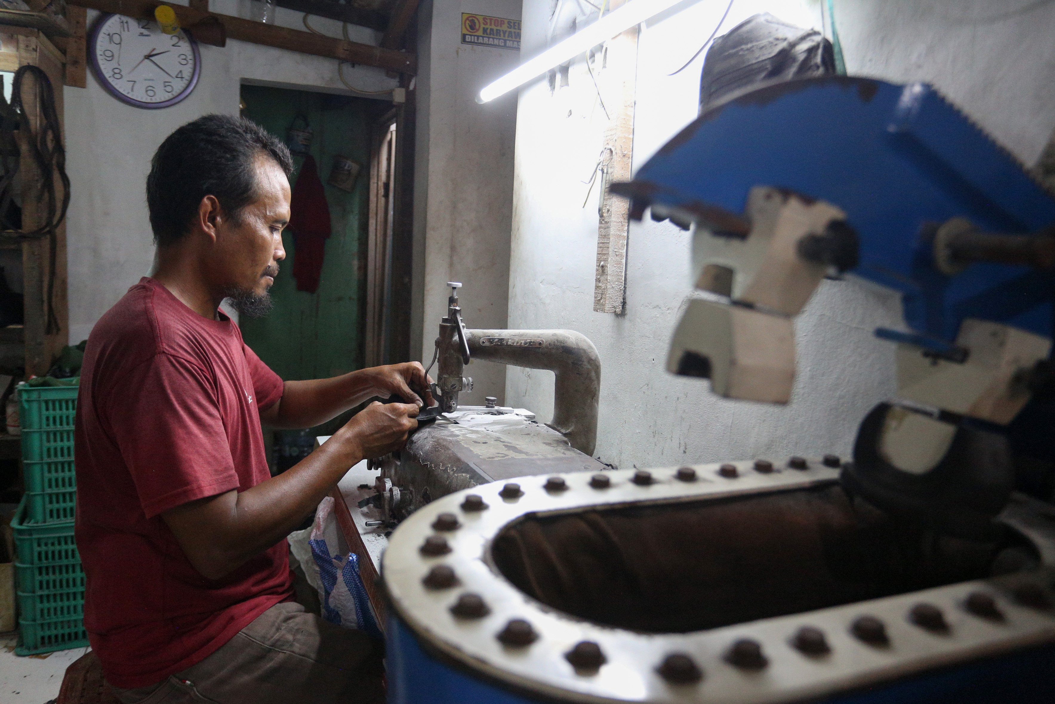 Pekerja menyelesaikan pembuatan sepatu di rumah produksi sepatu kulit Flavio & Boston, Penggilingan, Cakung, Jakarta Timur, Kamis (8/5/2025). Industri rumahan yang telah beroperasi sejak tahun 1980 ini mampu menghasilkan 1000 pasang sepatu per bulannya dengan rata-rata penjualan sebanyak 800 hingga 900 pasang sepatu.
