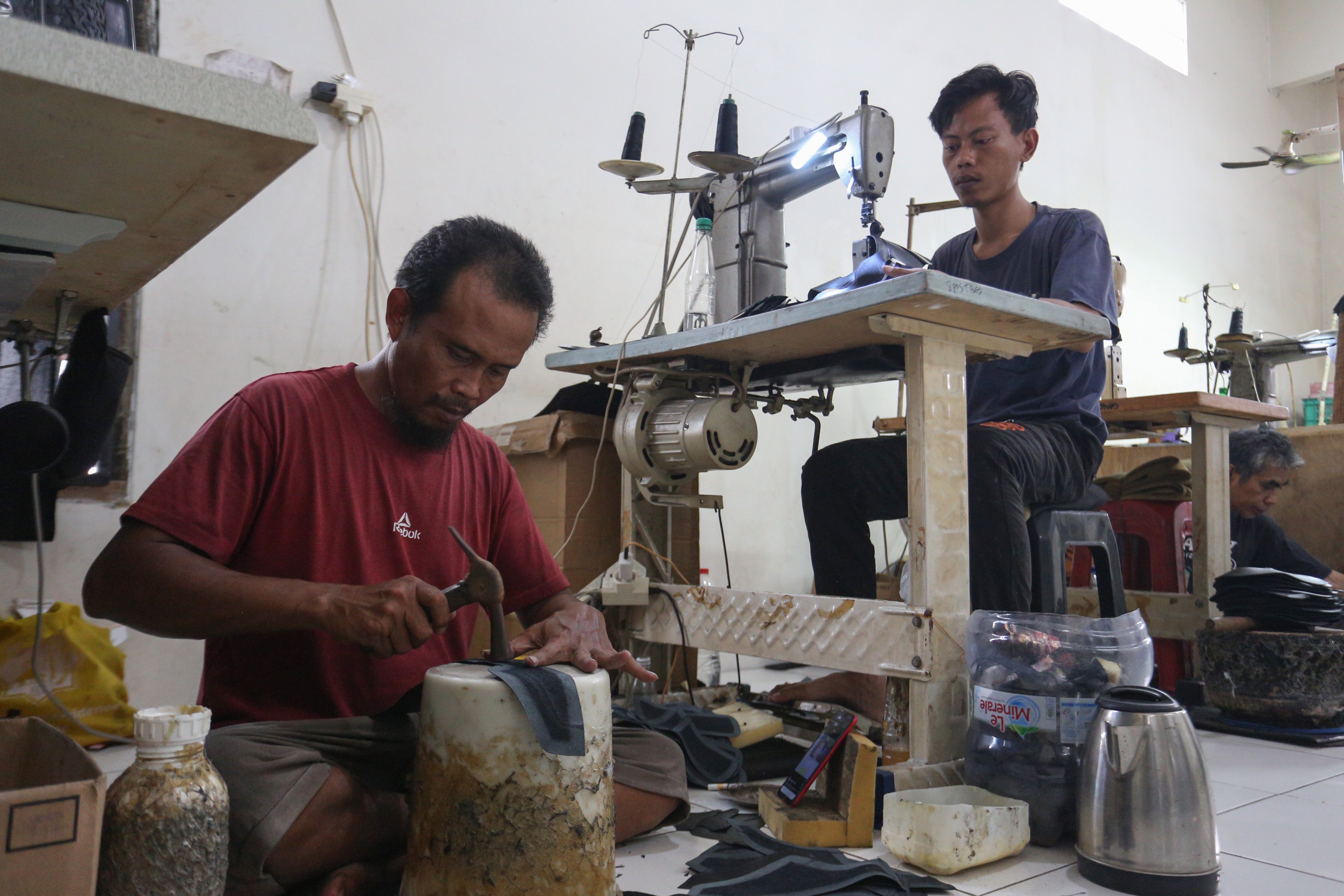 Pekerja menyelesaikan pembuatan sepatu di rumah produksi sepatu kulit Flavio & Boston, Penggilingan, Cakung, Jakarta Timur, Kamis (8/5/2025). Industri rumahan yang telah beroperasi sejak tahun 1980 ini mampu menghasilkan 1000 pasang sepatu per bulannya dengan rata-rata penjualan sebanyak 800 hingga 900 pasang sepatu.