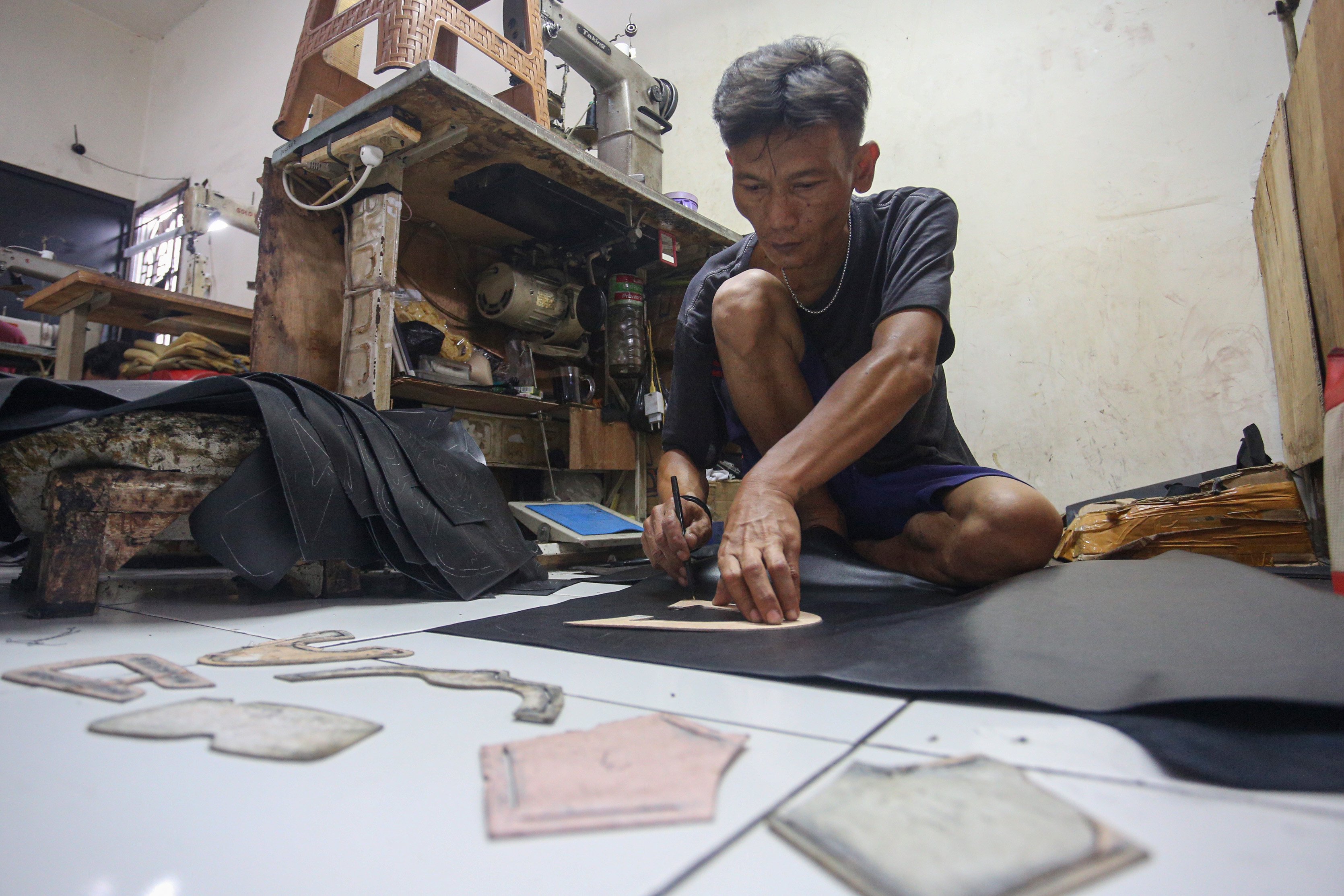 Pekerja menggambar pola pada bahan sepatu di rumah produksi sepatu kulit Flavio & Boston, Penggilingan, Cakung, Jakarta Timur, Kamis (8/5/2025). Industri rumahan yang telah beroperasi sejak tahun 1980 ini mampu menghasilkan 1000 pasang sepatu per bulannya dengan rata-rata penjualan sebanyak 800 hingga 900 pasang sepatu. 