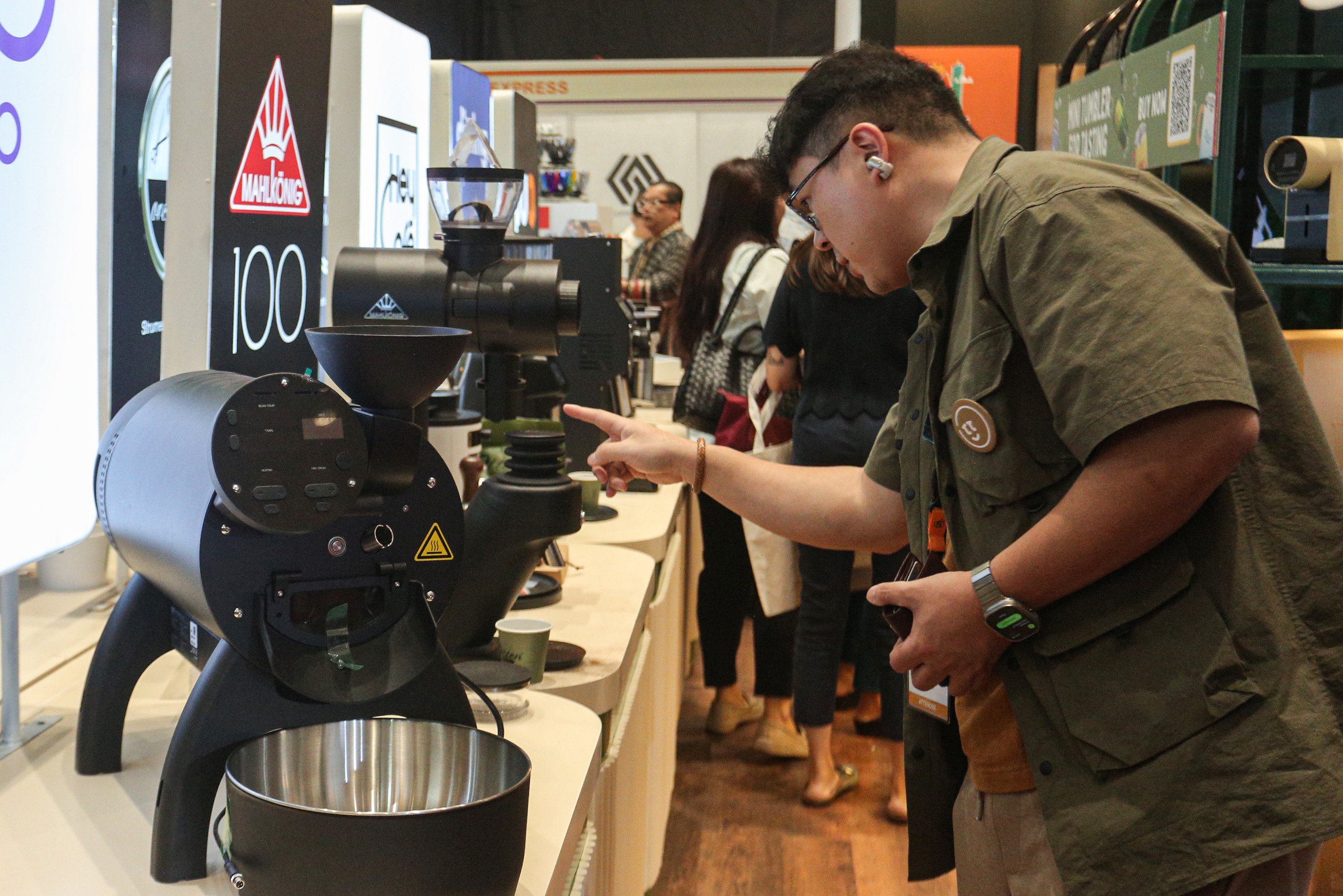 Pengunjung melihat mesin pengolahan kopi di salah satu stan pada pameran World of Coffee Jakarta 2025 di Jakarta International Convention Center (JICC), Kamis (15/5/2025). Pameran yang pertama kali diadakan di Indonesia dan berlangsung hingga 17 Mei 2025 ini diikuti oleh lebih dari 400 merek kopi terkemuka yang menjadi wadah bagi pelaku industri, pemerintah dan para profesional kopi global dalam menemukan peluang bisnis di industri tersebut.