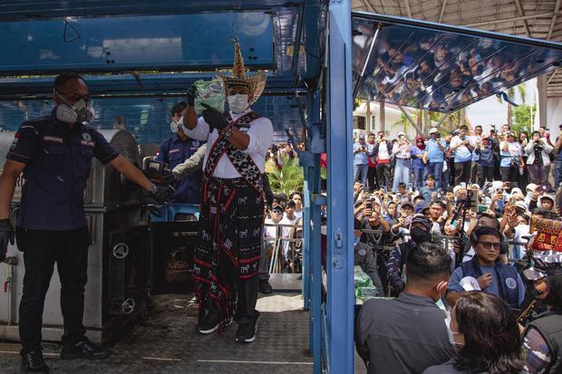 Seorang perwakilan dari warga mengenakan pakaian adat memperlihatkan ang bukti kejahatan kasus penyelundupan sabu-sabu sebelum dimusnahkan didalam kegiatan Pesta Rakyat Antinarkoba di alun-alun dataran Engku Putri, Batam, Kepulauan Riau, Kamis (12/6/2025). Dalam kegiatan tersebut, BNN memusnahkan 2 ton sabu hasil sitaan dari enam orang tersangka jaringan narkotika internasional Asia Tenggara sebagai bagian dari upaya mengedukasi masyarakat sekaligus meningkatkan kesadaran akan bahaya penyalahgunaan narkoba.