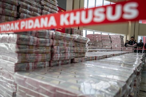 Petugas merapikan ang bukti uang sitaan saat konferensi pers kasus korupsi ekspor crude palm oil (CPO) di Gedung Bundar Jampidus Kejaksaaan Agung (Kejagung), Jakarta, Selasa (17/6/2025). Kejagung menyita Rp11,8 triliun lebih yang merupakan penyerahan dari lima terdakwa korporasi dalam Wilmar Group terkait kasus korupsi ekspor CPO.