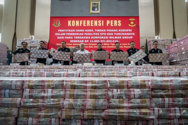 Direktur Penuntutan Kejaksaan Agung Sutikno (keempat kanan) bersama Direktur Penyidikan Jampidsus Abdul Qohar (ketiga kiri), Kepala Pusat penerangan Hukum (Kapuspenkum) Harli Siregar (keempat kiri) dan sejumlah pejabat terkait menunjukkan ang bukti uang sitaan saat konferensi pers kasus korupsi ekspor crude palm oil (CPO) di Gedung Bundar Jampidus Kejaksaaan Agung (Kejagung), Jakarta, Selasa (17/6/2025). 