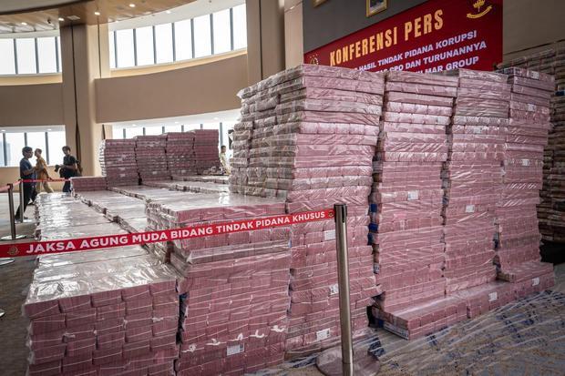 Petugas berjalan didekat ang bukti uang sitaan saat konferensi pers kasus korupsi ekspor crude palm oil (CPO) di Gedung Bundar Jampidus Kejaksaaan Agung (Kejagung), Jakarta, Selasa (17/6/2025). Kejagung menyita Rp11,8 triliun lebih yang merupakan penyerahan dari lima terdakwa korporasi dalam Wilmar Group terkait kasus korupsi ekspor CPO.