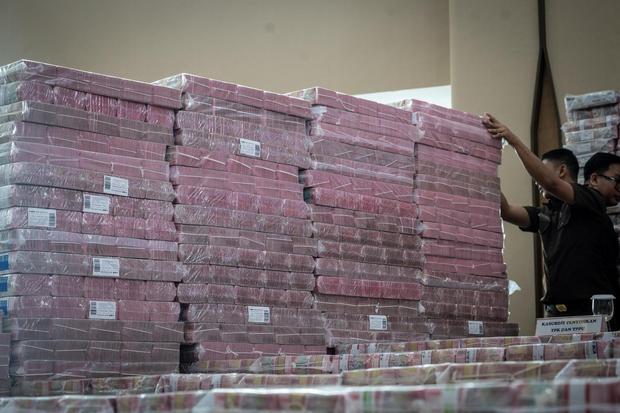 Petugas merapikan ang bukti uang sitaan saat konferensi pers kasus korupsi ekspor crude palm oil (CPO) di Gedung Bundar Jampidus Kejaksaaan Agung (Kejagung), Jakarta, Selasa (17/6/2025). Kejagung menyita Rp11,8 triliun lebih yang merupakan penyerahan dari lima terdakwa korporasi dalam Wilmar Group terkait kasus korupsi ekspor CPO.