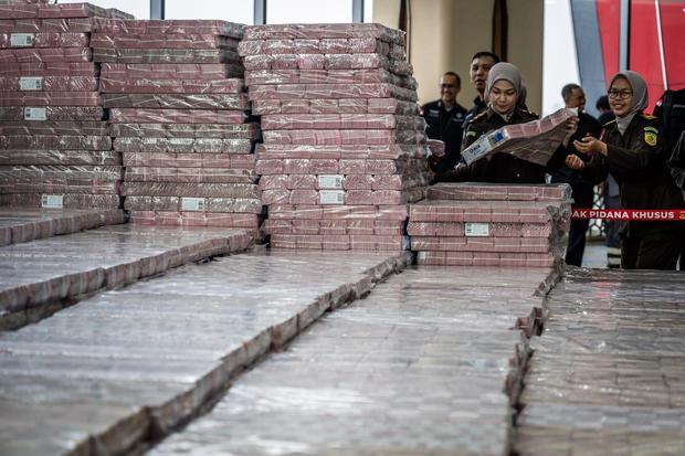 Petugas merapikan ang bukti uang sitaan saat konferensi pers kasus korupsi ekspor crude palm oil (CPO) di Gedung Bundar Jampidus Kejaksaaan Agung (Kejagung), Jakarta, Selasa (17/6/2025). Kejagung menyita Rp11,8 triliun lebih yang merupakan penyerahan dari lima terdakwa korporasi dalam Wilmar Group terkait kasus korupsi ekspor CPO.