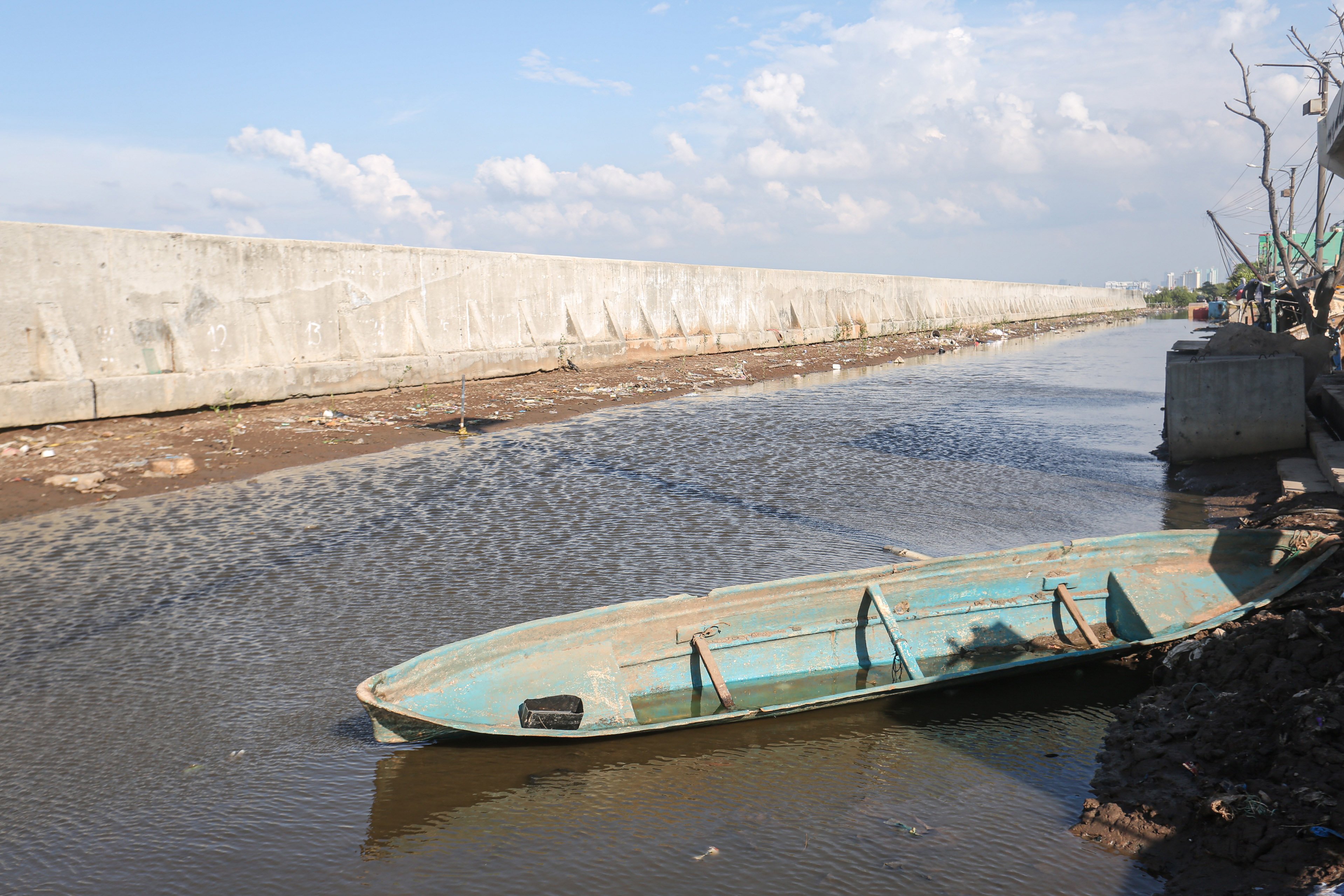 Sebuah sampan berada di dekat tanggul laut di kawasan Muara Baru, Penjaringan, Jakarta Utara, Senin (17/6/2025). Pemerintah Provinsi DKI Jakarta akan menggunakan surplus Anggaran Pendapatan dan Belanja Daerah (APBD) dan pendapatan dari pengolahan sampah menjadi energi listrik untuk membiayai pembangunan Giant Sea Wall atau tanggul laut raksasa.