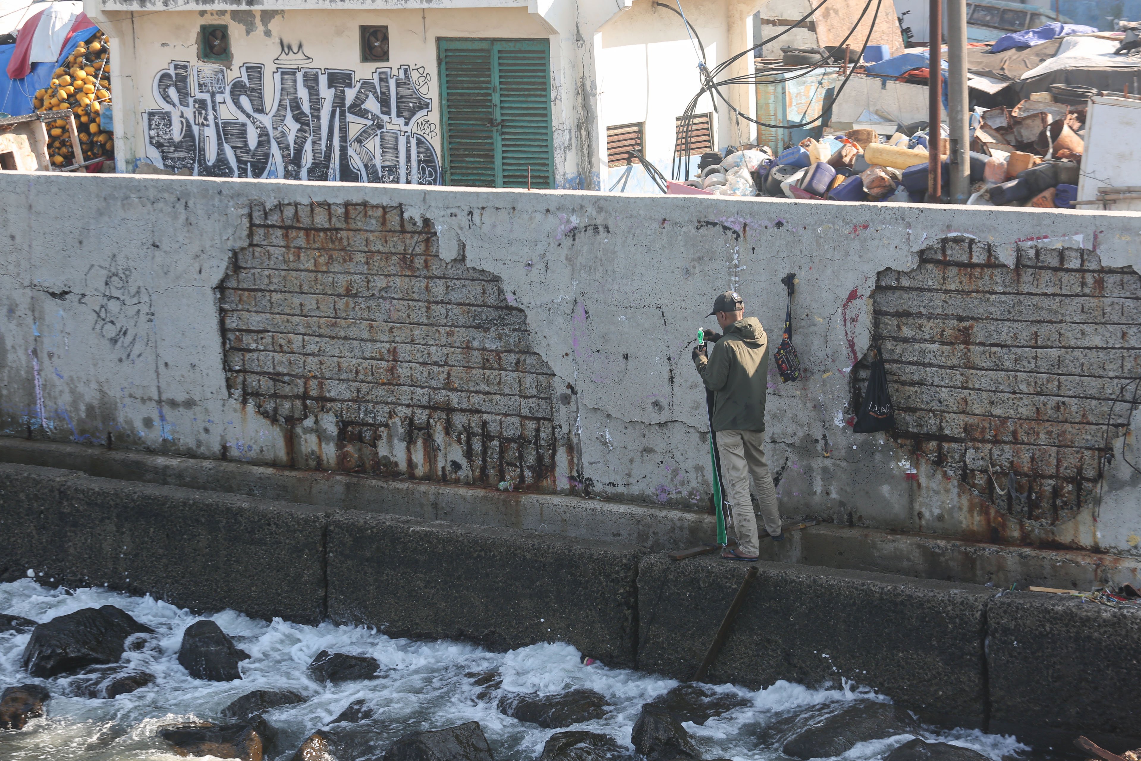 Warga berada di dekat tanggul laut di kawasan Muara Baru, Penjaringan, Jakarta Utara, Senin (17/6/2025). Pemerintah Provinsi DKI Jakarta akan menggunakan surplus Anggaran Pendapatan dan Belanja Daerah (APBD) dan pendapatan dari pengolahan sampah menjadi energi listrik untuk membiayai pembangunan Giant Sea Wall atau tanggul laut raksasa. 