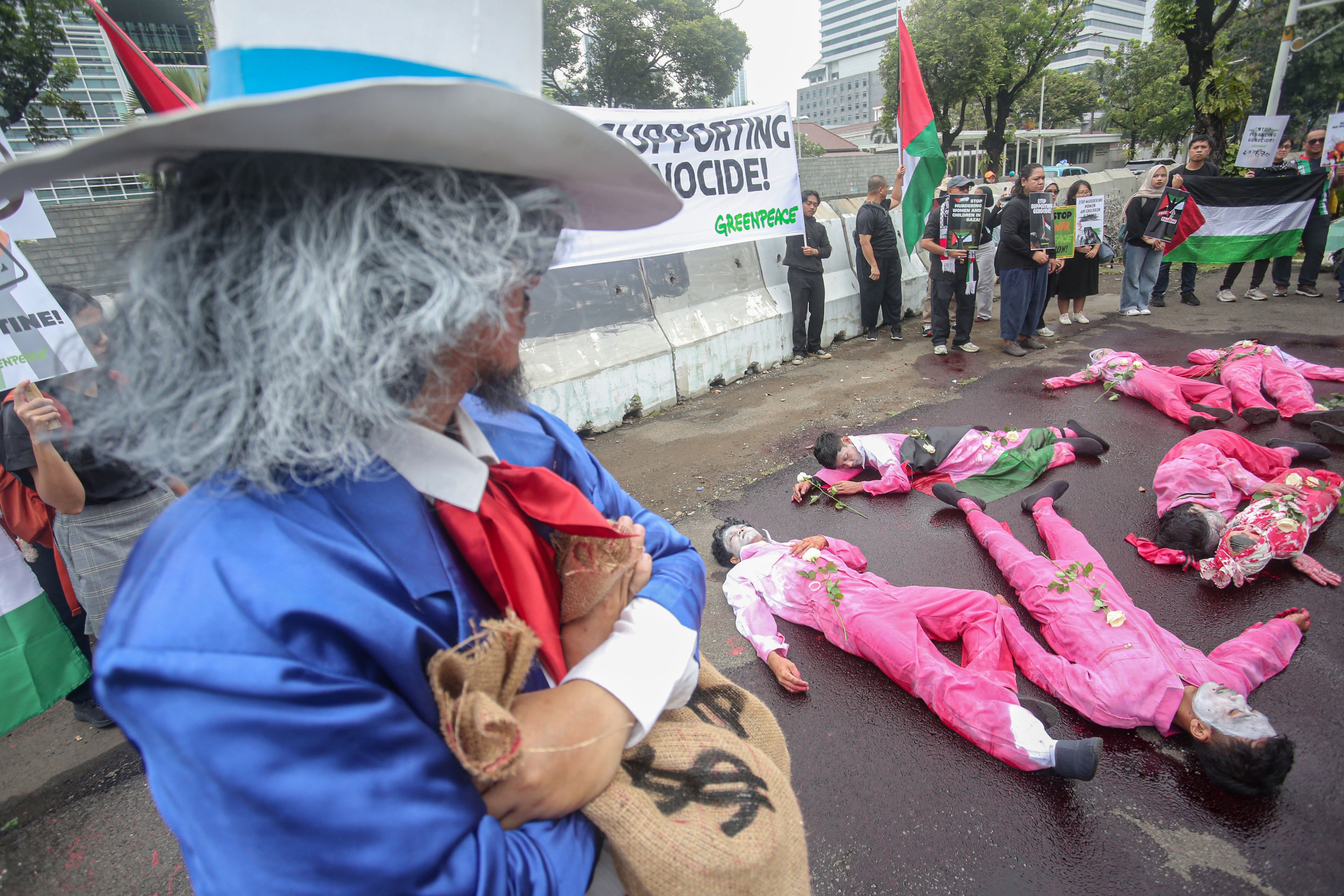 Aktivis Greenpeace Indonesia melakukan aksi teatrikal saat menggelar aksi solidaritas untuk masyarakat Gaza di depan Kedutaan Besar Amerika Serikat, Jakarta, Kamis (19/6/2025). Dalam aksinya tersebut mereka menyerukan kepada semua pihak termasuk pemerintah Amerika Serikat untuk bekerja sama dalam upaya menghentikan genosida di Palestina yang dilakukan oleh Israel.