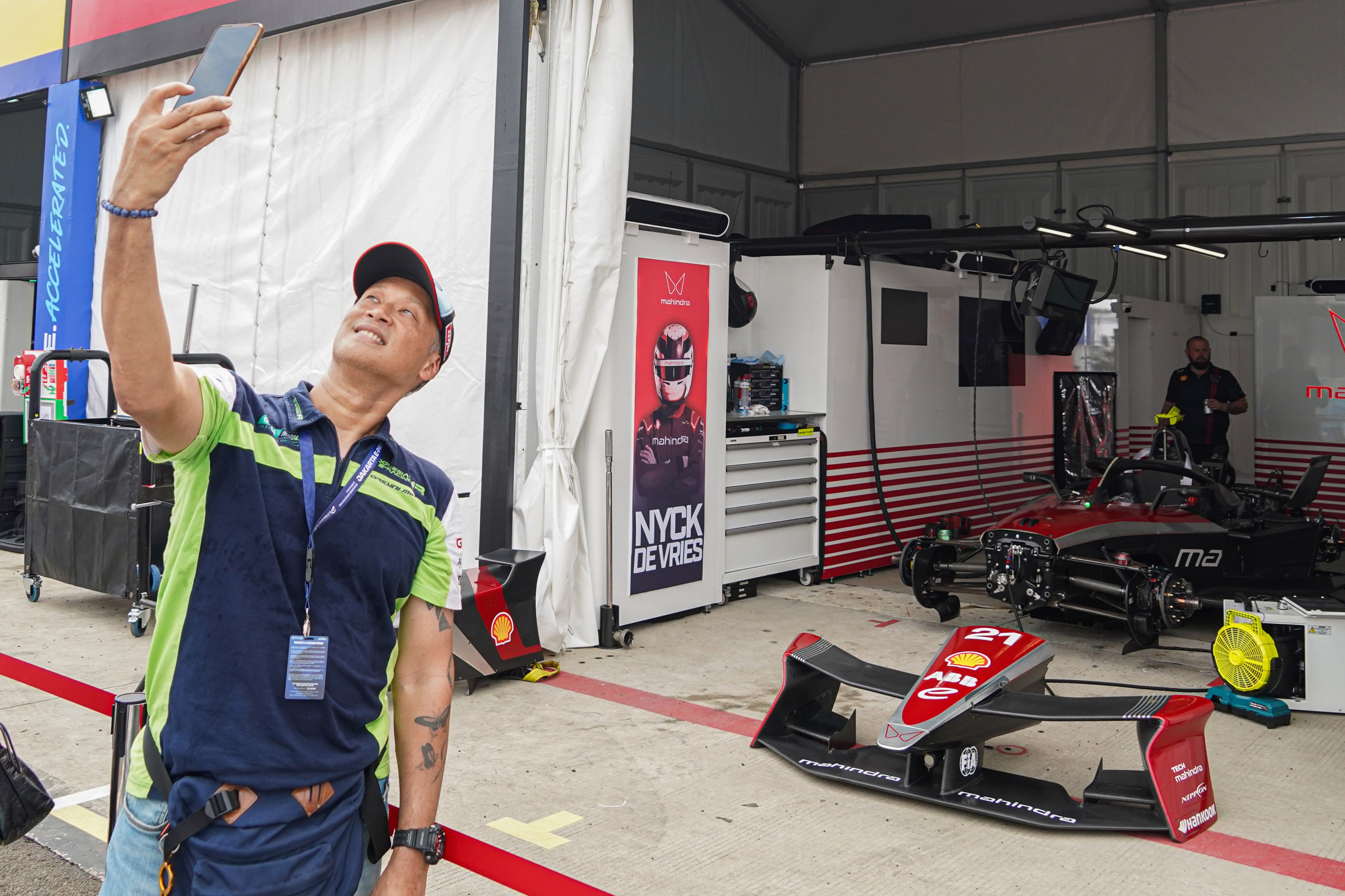 Penonton berfoto dengan mobil balap listrik dari pembalap tim Mahindra Racing Nyck De Vries saat sebelum dimulainya balapan Formula E World Championship 2025 seri ke-12 di Jakarta International E-Prix Circuit (JIEC), Sabtu (21/6/2025). Ajang balap mobil listrik yang digelar di lintasan sepanjang 2,37 kilometer ini diikuti oleh 22 pembalap dari 11 tim. 