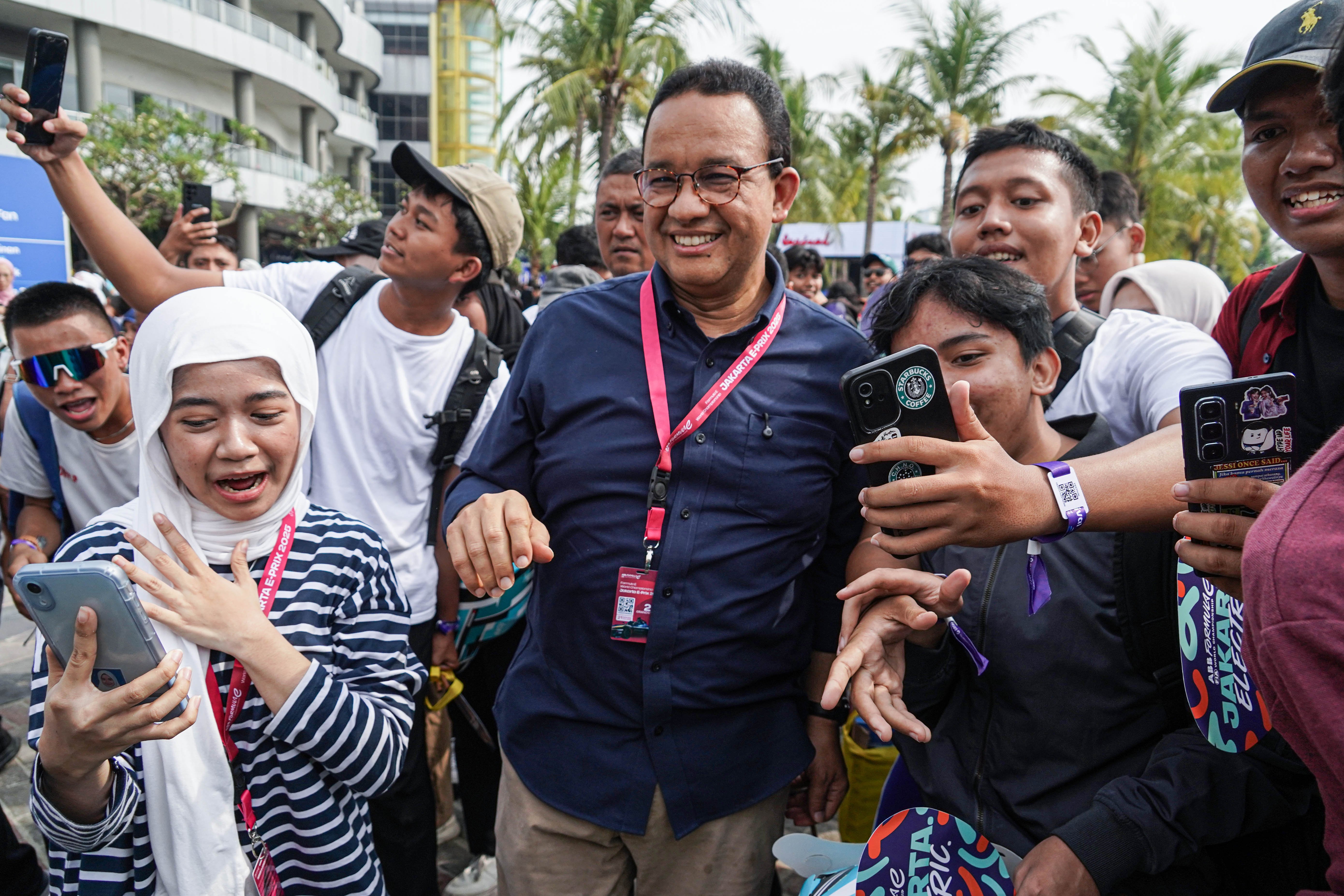 Sejumlah warga berebut untuk berfoto bersama mantan Gubernur DKI Jakarta Anies Baswedan saat akan menyaksikan balapan Formula E World Championship 2025 seri ke-12 di Jakarta International E-Prix Circuit (JIEC), Sabtu (21/6/2025). Ajang balap mobil listrik yang digelar di lintasan sepanjang 2,37 kilometer ini diikuti oleh 22 pembalap dari 11 tim. 