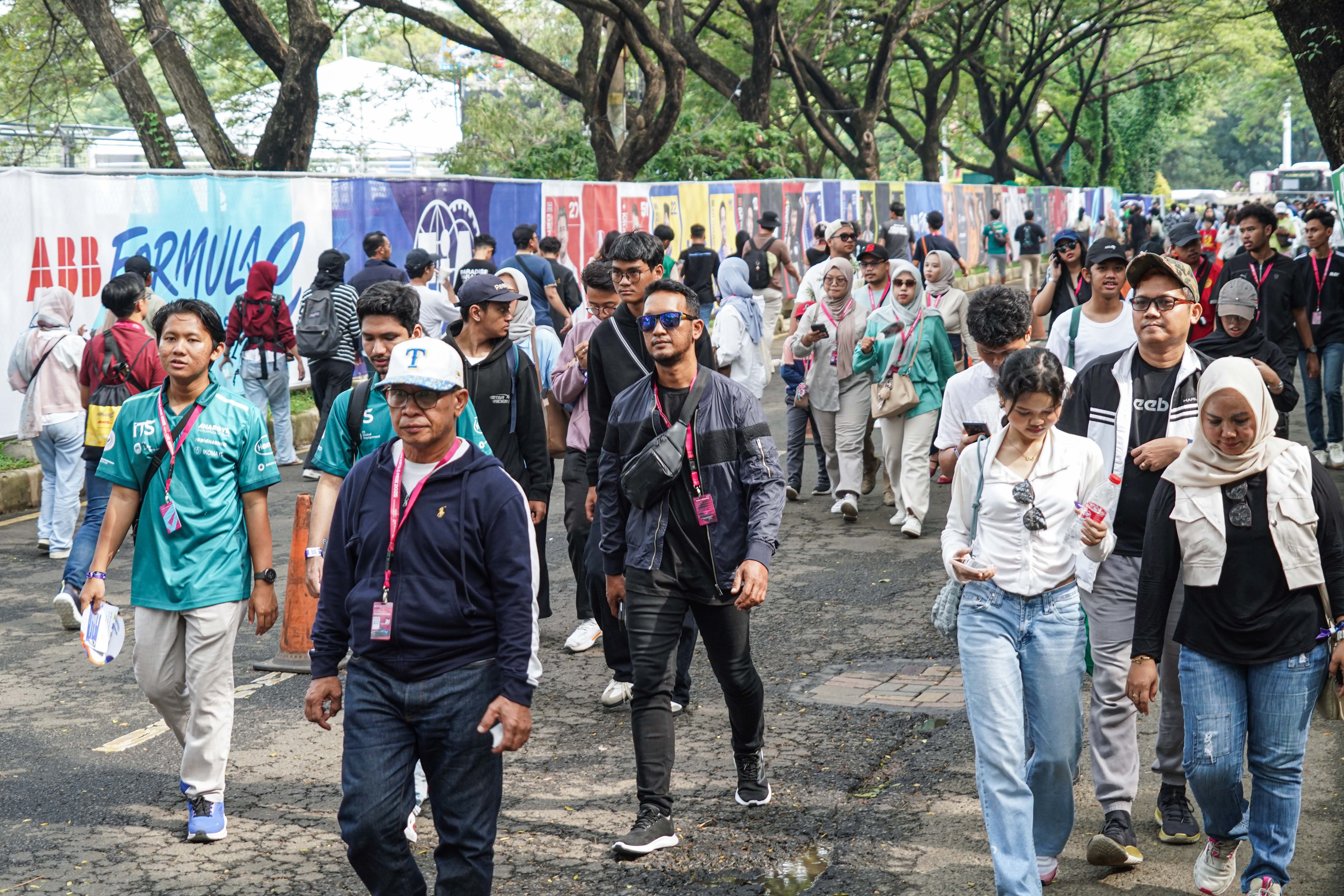 Penonton berjalan menuju tribun saat akan menyaksikan balapan Formula E World Championship 2025 seri ke-12 di Jakarta International E-Prix Circuit (JIEC), Sabtu (21/6/2025). Ajang balap mobil listrik yang digelar di lintasan sepanjang 2,37 kilometer ini diikuti oleh 22 pembalap dari 11 tim. 