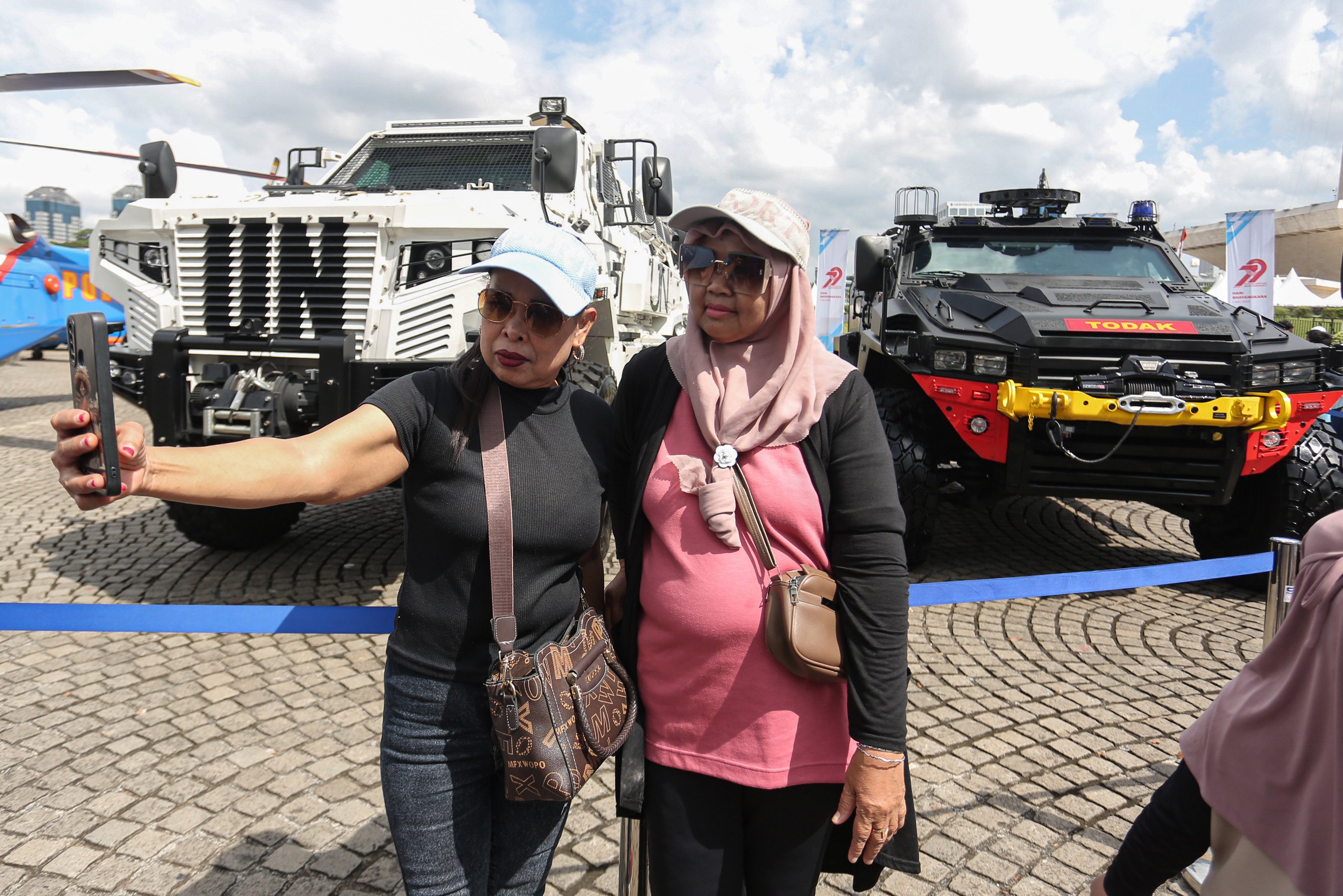 Warga berfoto dengan kendaraan taktis polisi usai upacara HUT ke-79 Bhayangkara di kawasan Monumen Nasional (Monas), Jakarta, Selasa (1/7/2025). Peringatan HUT Polri tahun ini mengusung tema \