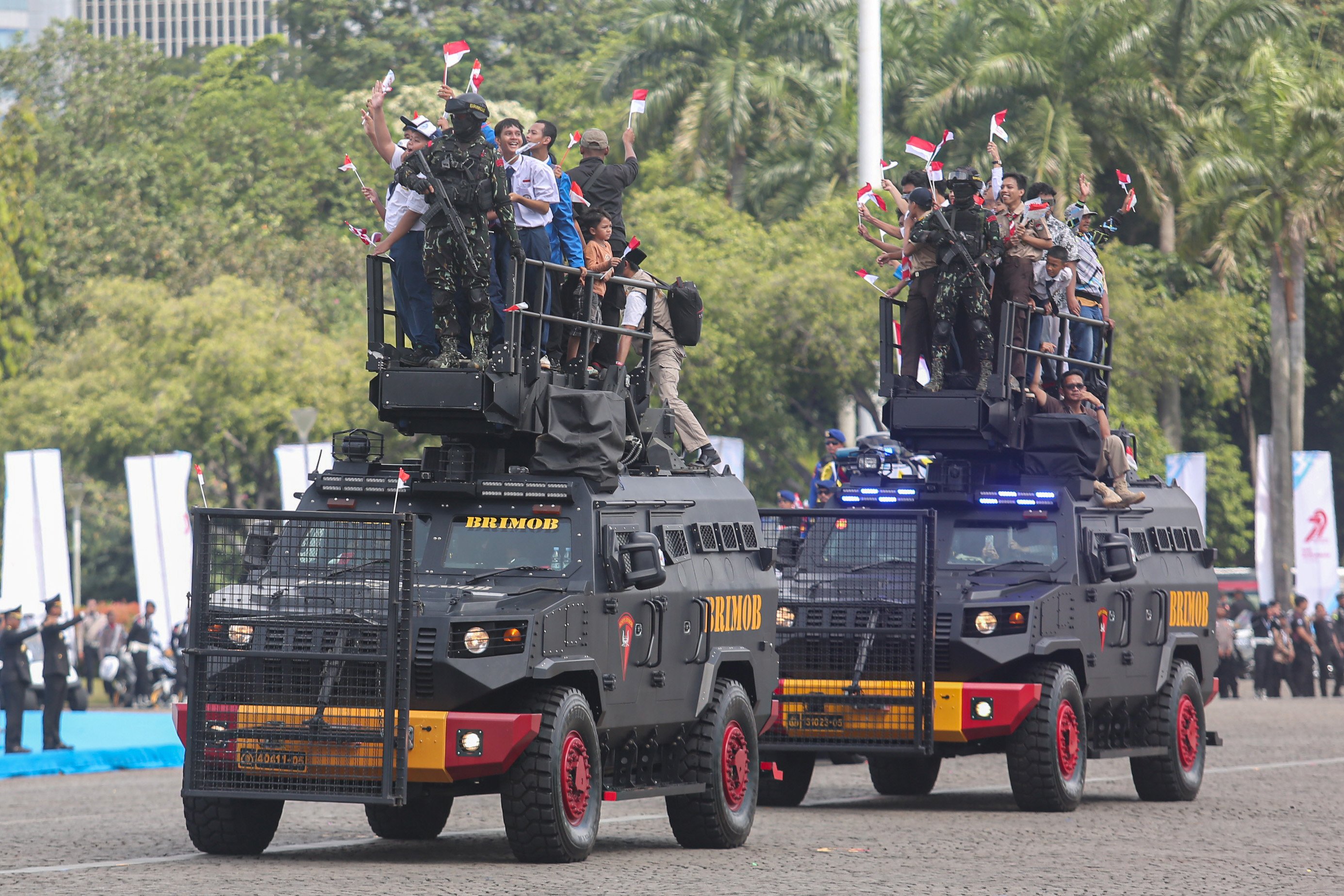 Sejumlah warga menaiki kendaraan taktis saat upacara HUT ke-79 Bhayangkara di kawasan Monumen Nasional (Monas), Jakarta, Selasa (1/7/2025). Peringatan HUT Polri tahun ini mengusung tema \