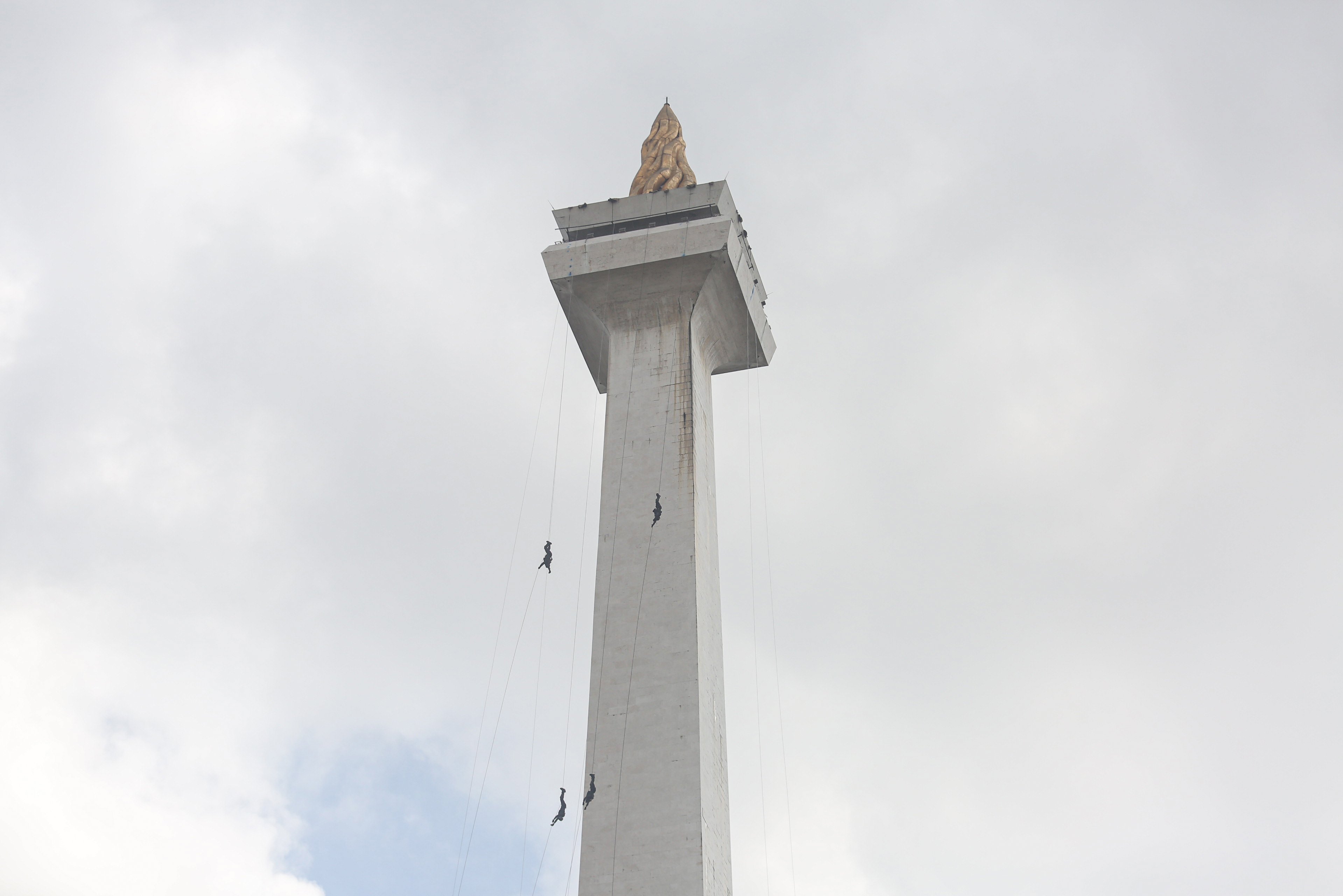 Sejumlah personel polisi melakukan atraksi menuruni tugu Monas saat upacara HUT ke-79 Bhayangkara di kawasan Monumen Nasional (Monas), Jakarta, Selasa (1/7/2025). Peringatan HUT Polri tahun ini mengusung tema \