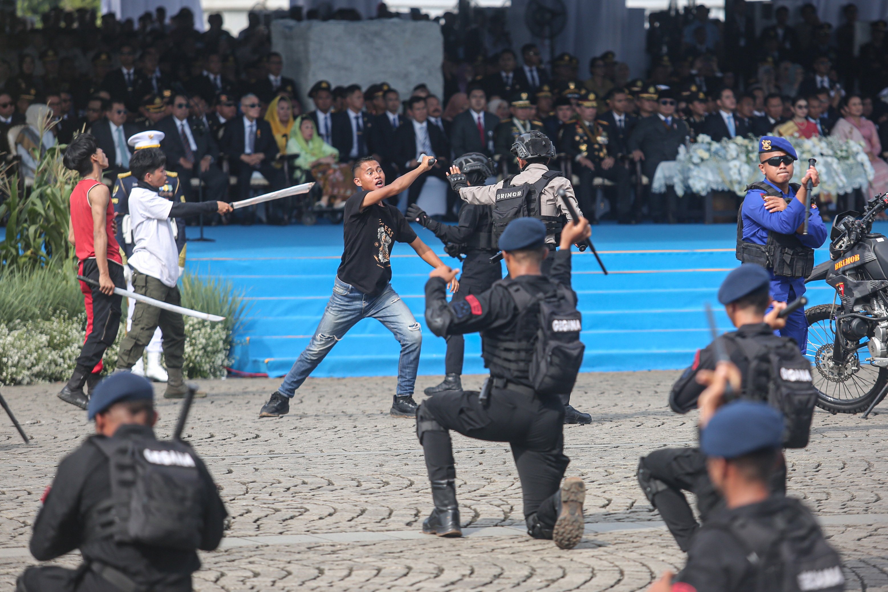 Sejumlah polisi melakukan simulasi pengamanan kejadian tawuran saat upacara HUT ke-79 Bhayangkara di kawasan Monumen Nasional (Monas), Jakarta, Selasa (1/7/2025). Peringatan HUT Polri tahun ini mengusung tema \