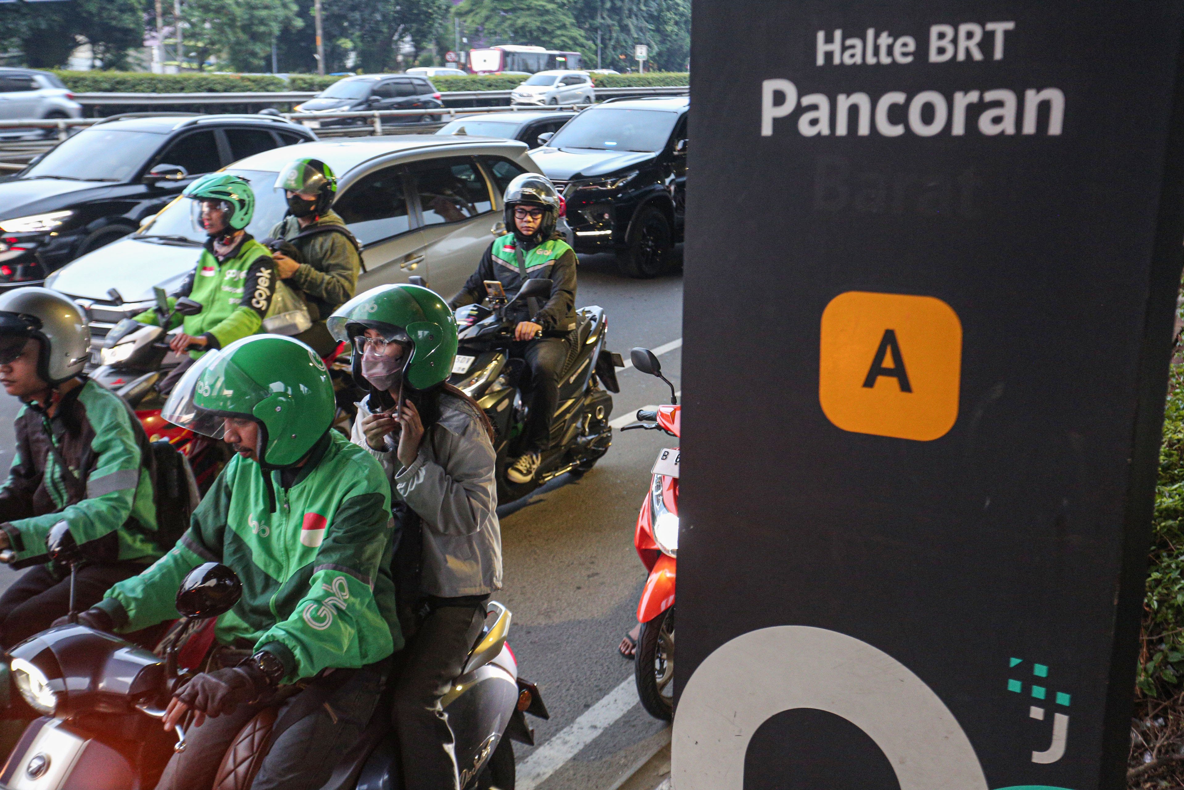 Pengemudi ojek online (ojol) membawa penumpang di Jalan Gatot Subroto, Jakarta, Kamis (3/7/2025). Kementerian Perhubungan (Kemenhub) tengah mengkaji kenaikan tarif ojol sebesar 8%-15% dengan jumlah eskalasi yang bervariasi tergantung zona wilayah masing-masing pengguna.