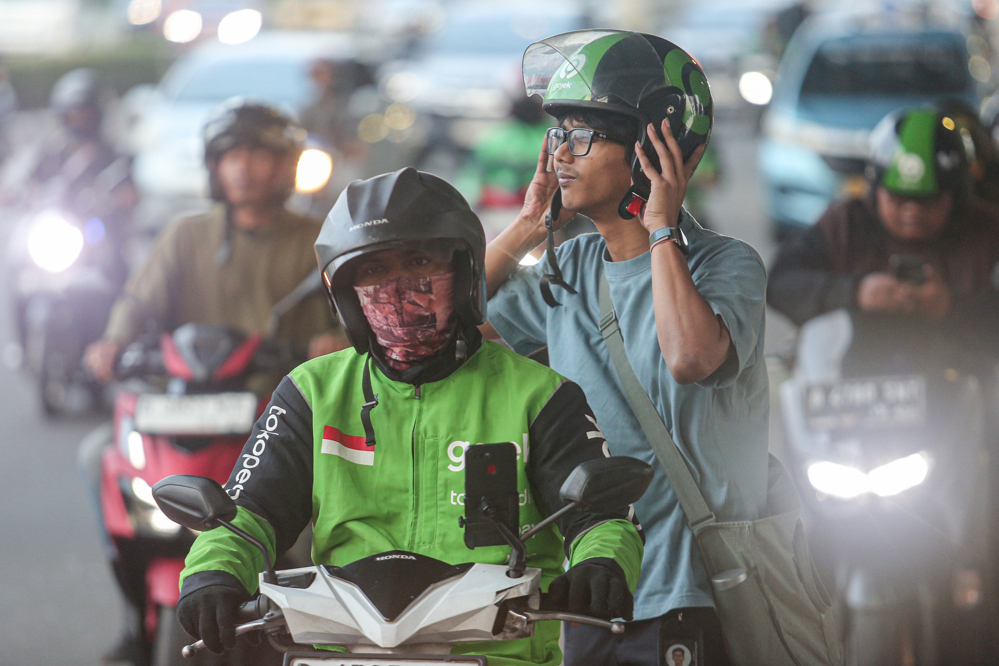 Pengemudi ojek online (ojol) membawa penumpang di Jalan Gatot Subroto, Jakarta, Kamis (3/7/2025). Kementerian Perhubungan (Kemenhub) tengah mengkaji kenaikan tarif ojol sebesar 8%-15% dengan jumlah eskalasi yang bervariasi tergantung zona wilayah masing-masing pengguna.
