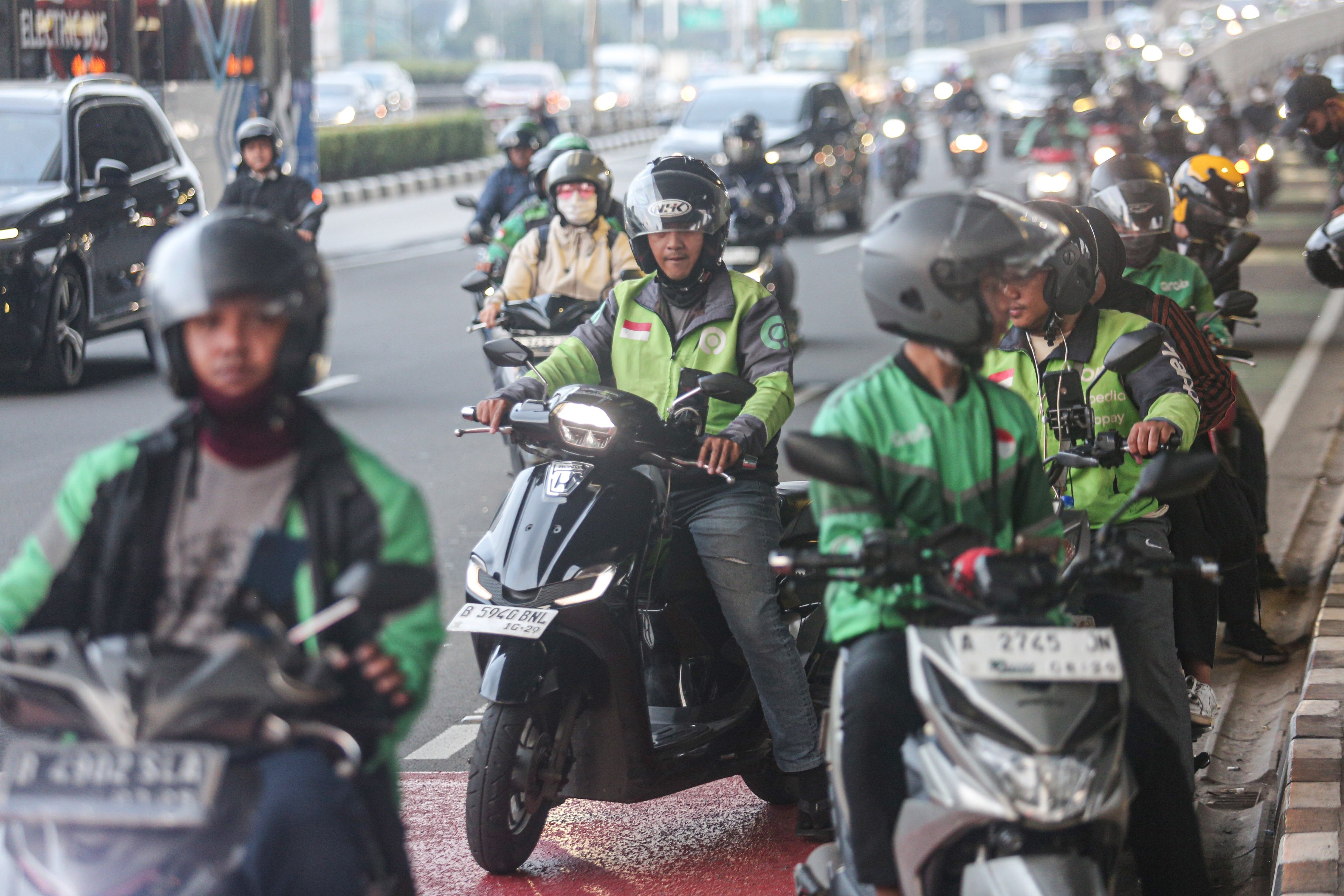 pengemudi ojek online (ojol) melintas di Jalan Gatot Subroto, Jakarta, Kamis (3/7/2025). Kementerian Perhubungan (Kemenhub) tengah mengkaji kenaikan tarif ojol sebesar 8%-15% dengan jumlah eskalasi yang bervariasi tergantung zona wilayah masing-masing pengguna.