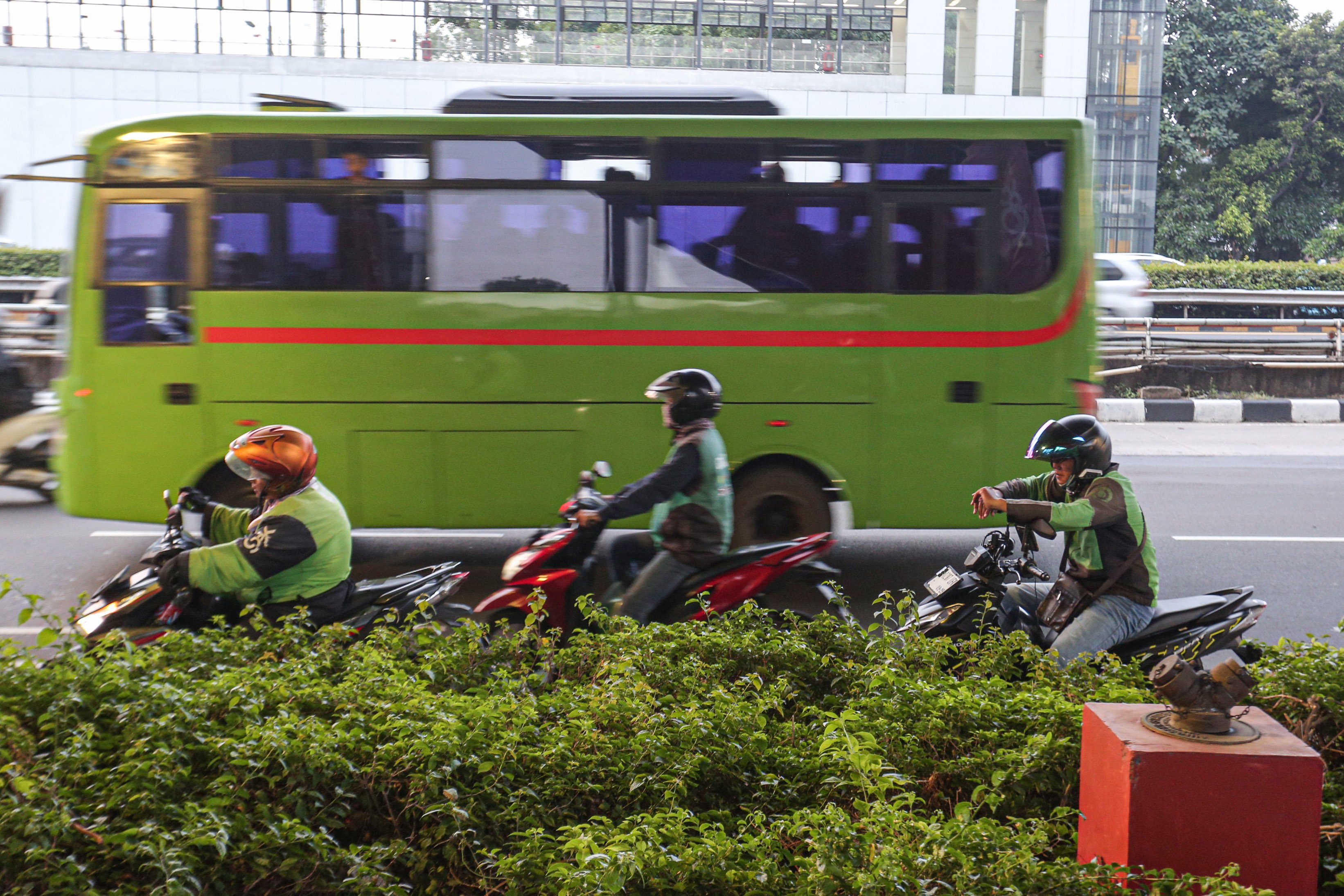 Tiga pengemudi ojek online (ojol) menunggu orderan di Jalan Gatot Subroto, Jakarta, Kamis (3/7/2025). Kementerian Perhubungan (Kemenhub) tengah mengkaji kenaikan tarif ojol sebesar 8%-15% dengan jumlah eskalasi yang bervariasi tergantung zona wilayah masing-masing pengguna.
