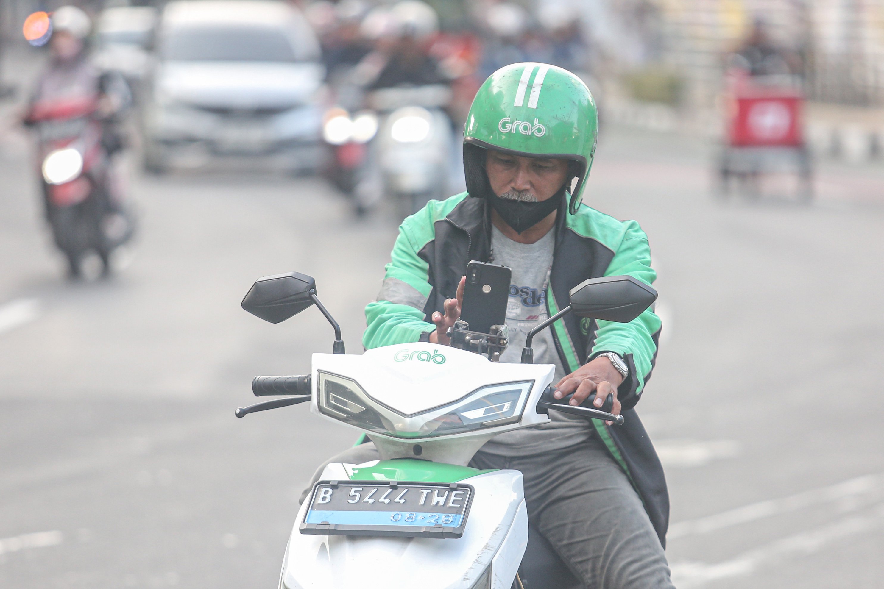 Seorang pengemudi ojek online (ojol) menunggu orderan di kawasan Blok M, Jakarta, Kamis (3/7/2025). Kementerian Perhubungan (Kemenhub) tengah mengkaji kenaikan tarif ojol sebesar 8%-15% dengan jumlah eskalasi yang bervariasi tergantung zona wilayah masing-masing pengguna.