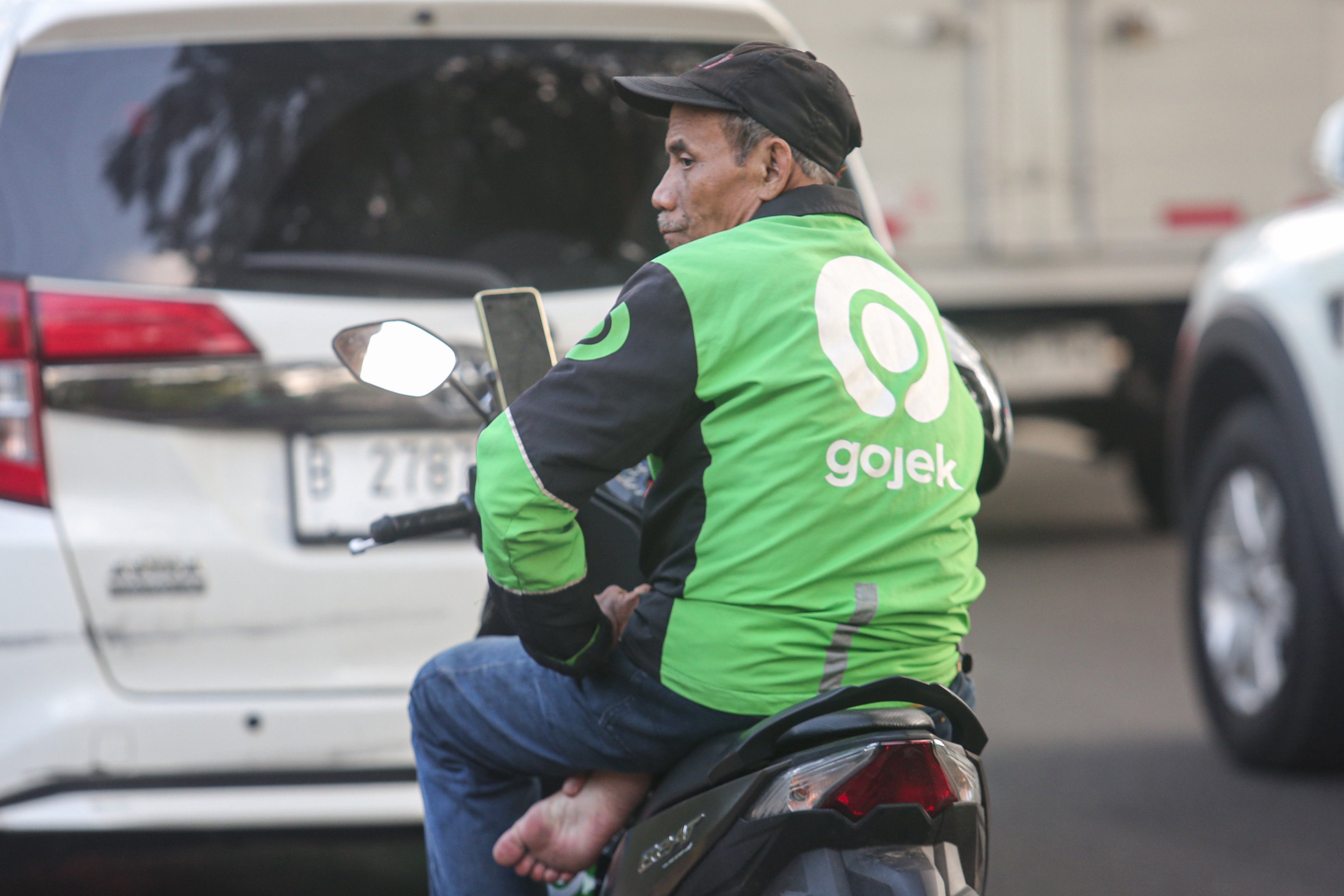 Seorang pengemudi ojek online (ojol) menunggu orderan di kawasan Palmerah, Jakarta, Kamis (3/7/2025). Kementerian Perhubungan (Kemenhub) tengah mengkaji kenaikan tarif ojol sebesar 8%-15% dengan jumlah eskalasi yang bervariasi tergantung zona wilayah masing-masing pengguna.