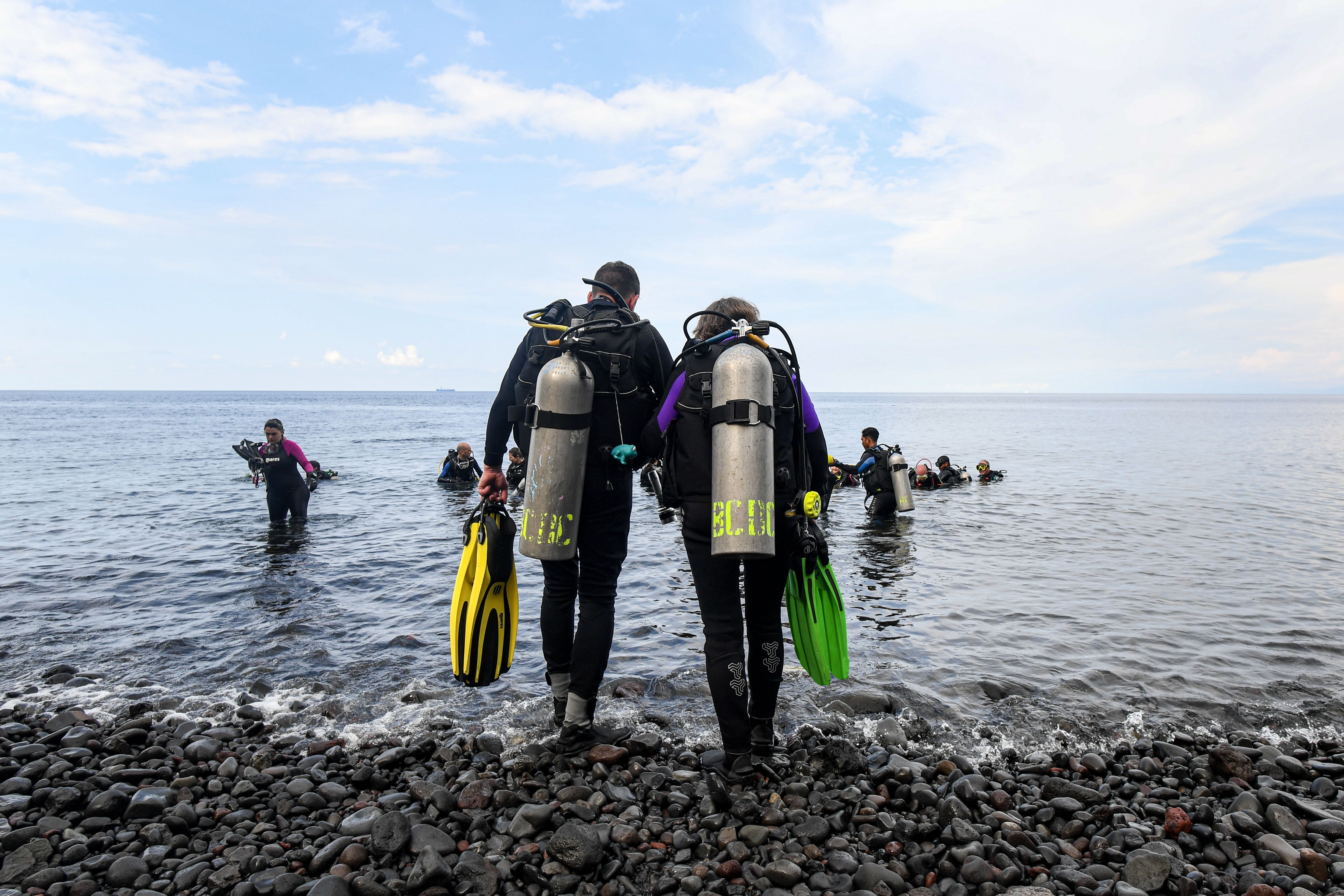 Sejumlah wisatawan berjalan untuk melakukan penyelaman di Perairan Laut Tulamben di Desa Tulamben, Kubu, Karangasem, Bali.