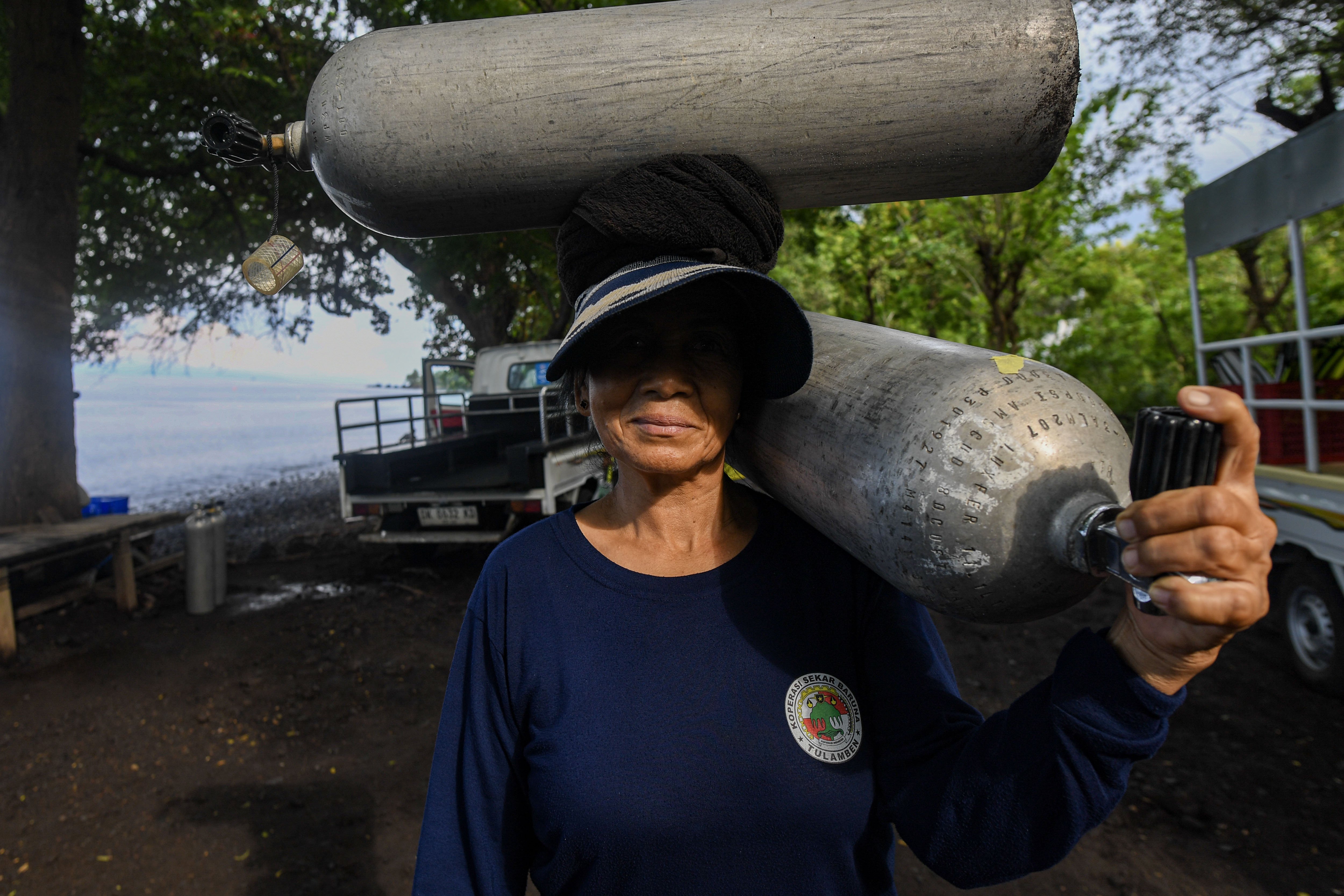 Seorang porter membawakan tabung selam di Desa Tulamben, Kubu, Karangasem, Bali.