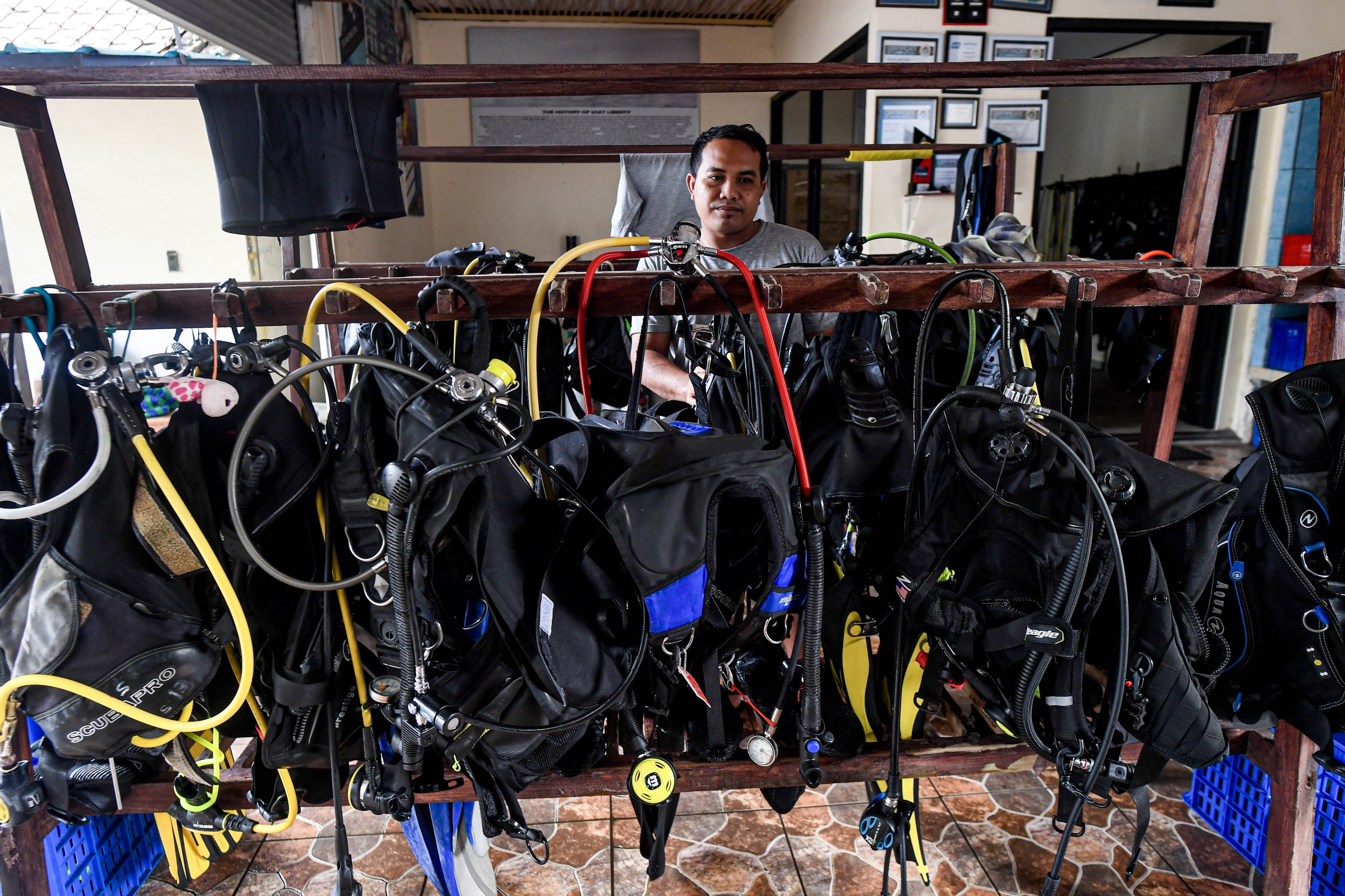 Petugas pusat penyelaman (dive center) menyiapkan perlengkapan selam Alat Pengendali Daya Apung (BCD) di Desa Tulamben, Kubu, Karangasem, Bali.