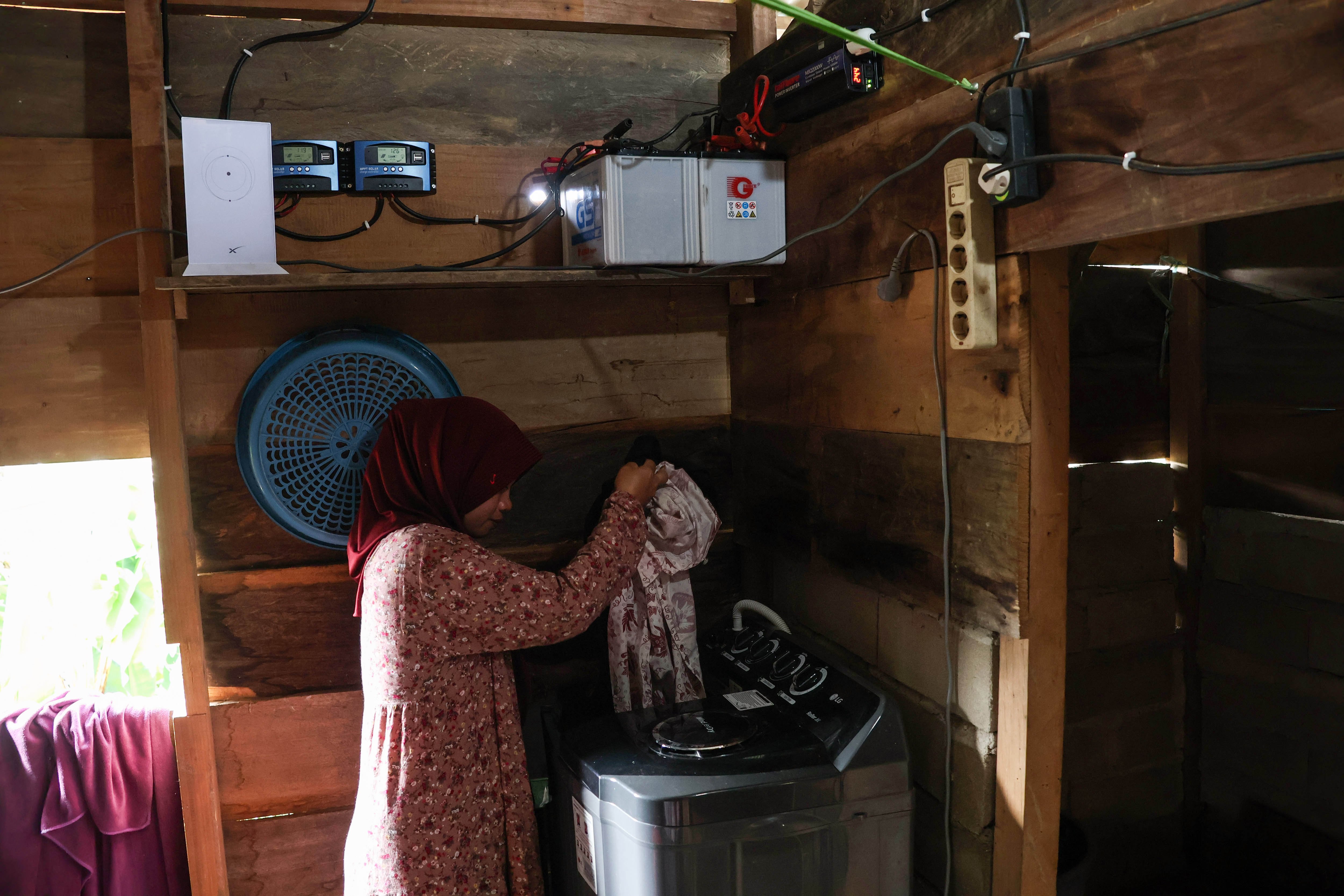 Seorang warga memasukkan pakain ke dalam mesin cuci di rumahnya di Dusun Lambiri, Desa Embonatana, Kecamatan Seko, Luwu Utara, Sulawesi Selatan.