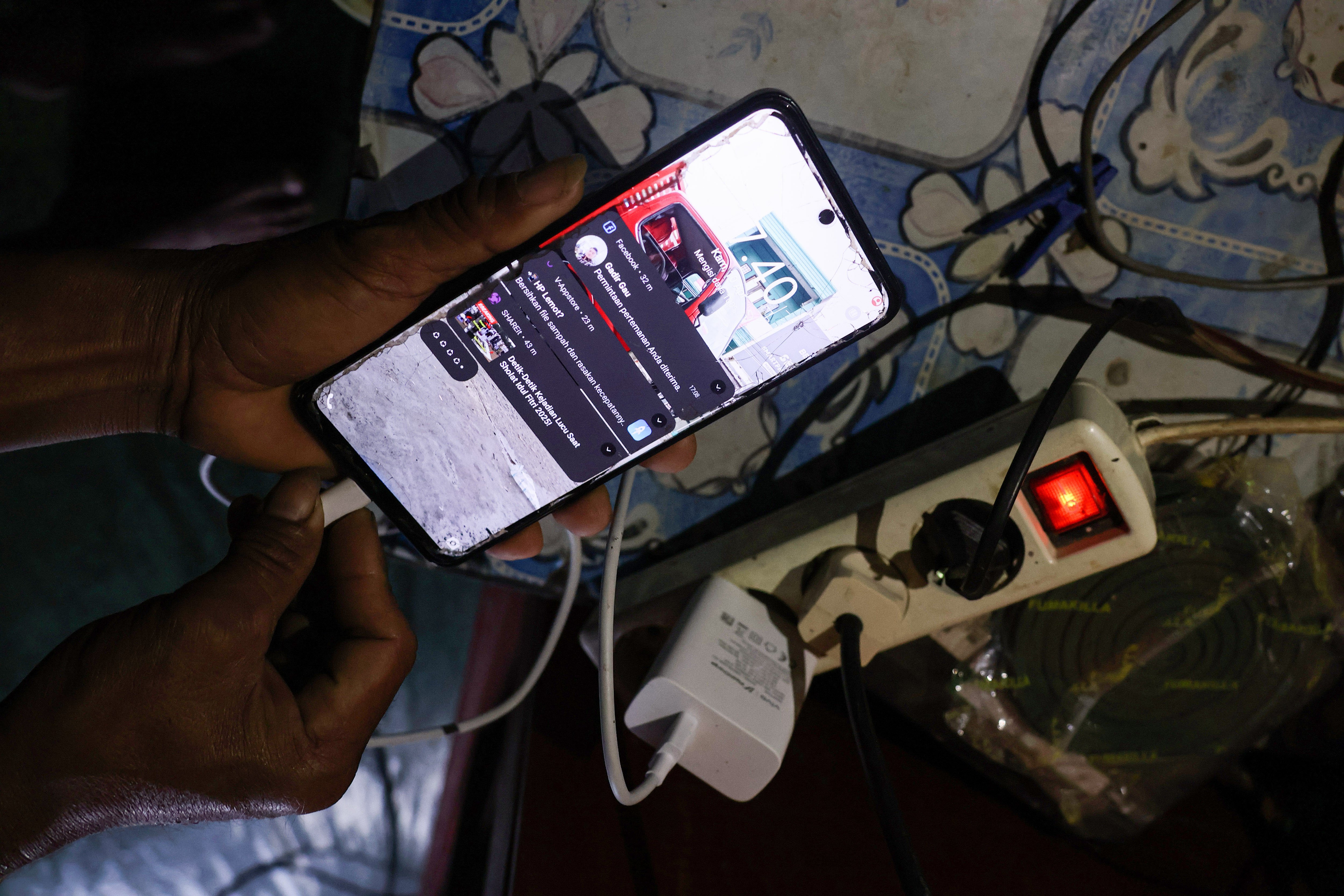 Warga mengisi daya telepon genggamnya menggunakan aliran listrik dari panel surya di Dusun Lambiri, Desa Embonatana, Kecamatan Seko, Luwu Utara, Sulawesi Selatan.