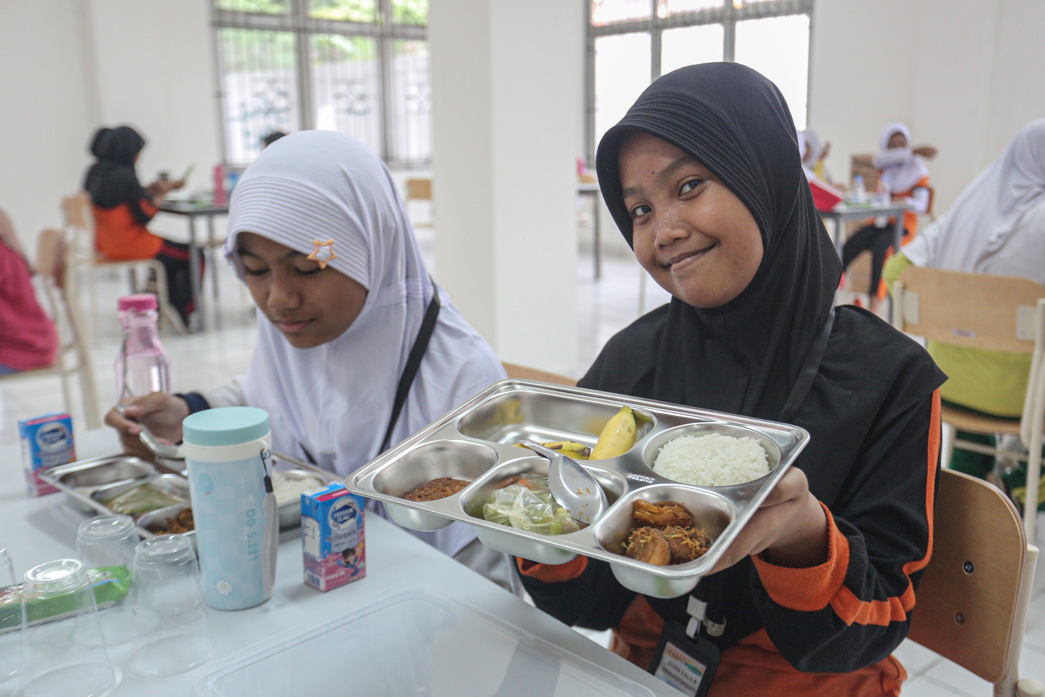 Siswa menunjukkan menu makan bergizi gratis saat mengikuti kegiatan Masa Pengenalan Lingkungan Sekolah (MPLS) di Sekolah Rakyat Menengah Pertama 6, Sentra Handayani, Bambu Apus, Jakarta Timur, Senin (14/7/2025). Pemerintah resmi memulai program Sekolah Rakyat pada tahap pertama yang dirancang sebagai sekolah berasrama dan diperuntukkan bagi siswa dari keluarga berpenghasilan rendah di 100 titik lokasi yang tersebar di seluruh wilayah Indonesia.