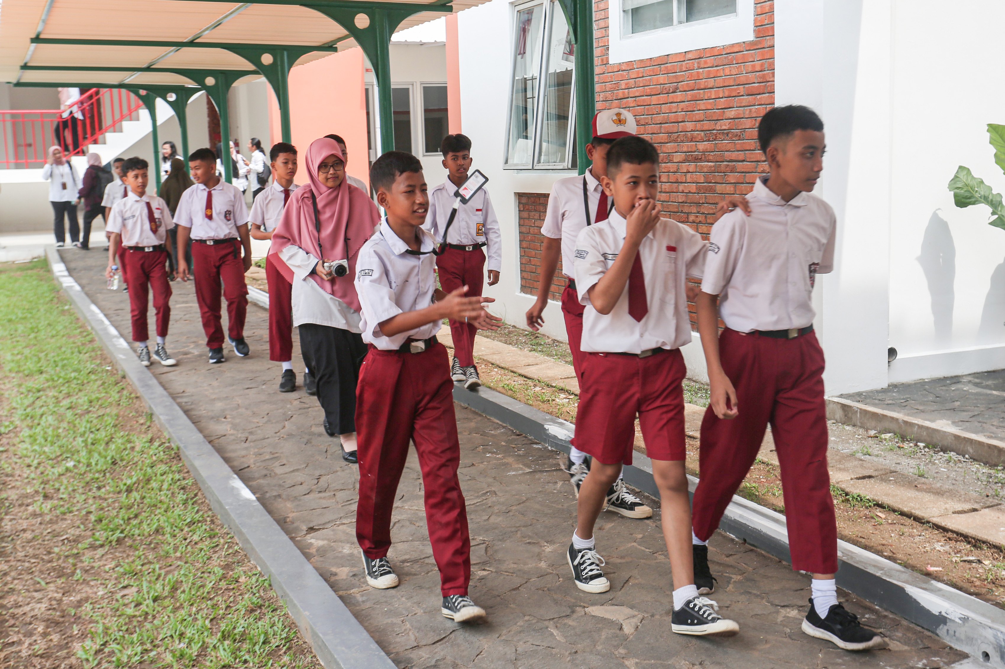 Sejumlah siswa berjalan untuk mengikuti kegiatan Masa Pengenalan Lingkungan Sekolah (MPLS) di Sekolah Rakyat Menengah Pertama 6, Sentra Handayani, Bambu Apus, Jakarta Timur, Senin (14/7/2025). Pemerintah resmi memulai program Sekolah Rakyat pada tahap pertama yang dirancang sebagai sekolah berasrama dan diperuntukkan bagi siswa dari keluarga berpenghasilan rendah di 100 titik lokasi yang tersebar di seluruh wilayah Indonesia.