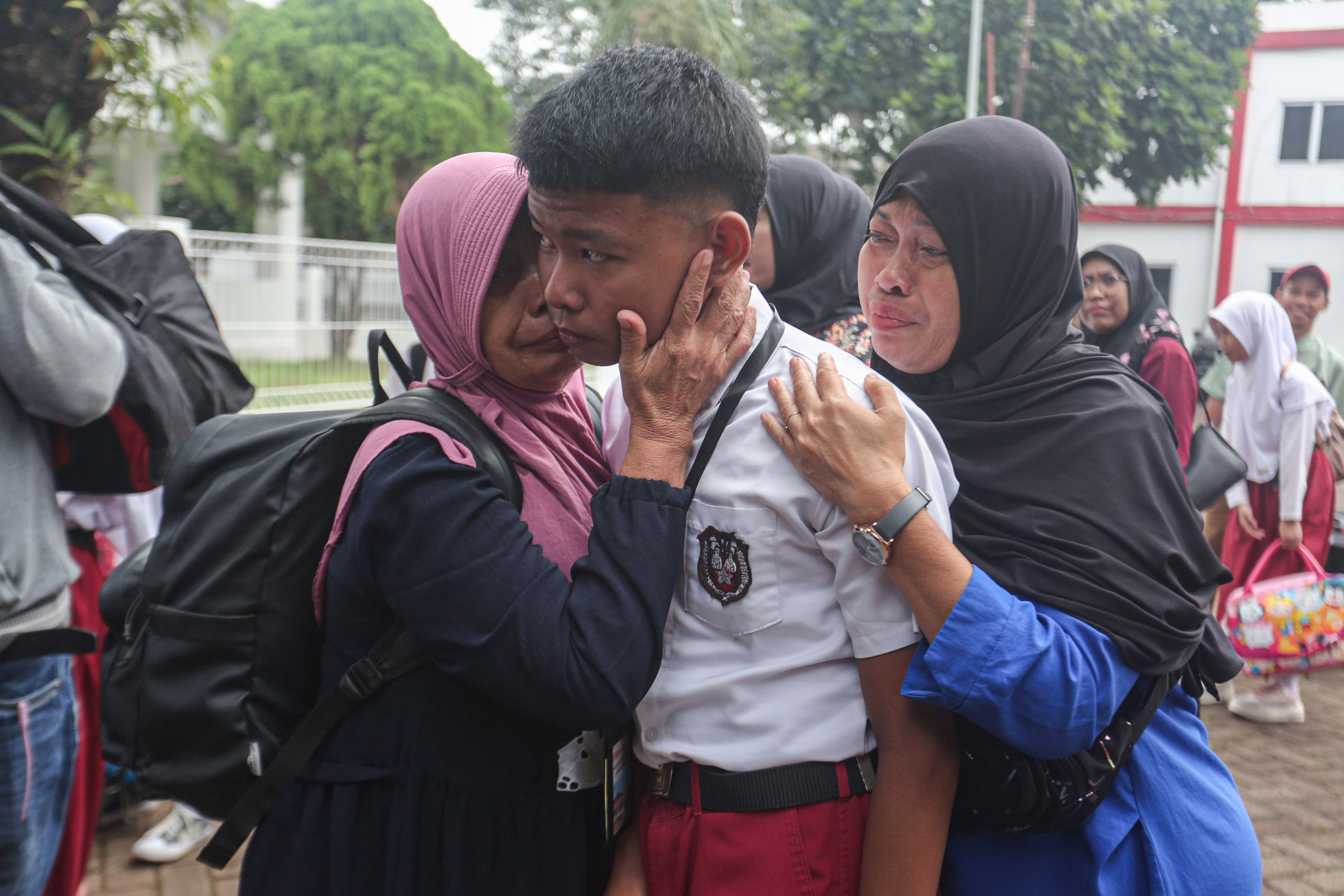 Orang tua memeluk anaknya yang akan mengikuti kegiatan Masa Pengenalan Lingkungan Sekolah (MPLS) di Sekolah Rakyat Menengah Pertama 6, Sentra Handayani, Bambu Apus, Jakarta Timur, Senin (14/7/2025). Pemerintah resmi memulai program Sekolah Rakyat pada tahap pertama yang dirancang sebagai sekolah berasrama dan diperuntukkan bagi siswa dari keluarga berpenghasilan rendah di 100 titik lokasi yang tersebar di seluruh wilayah Indonesia.