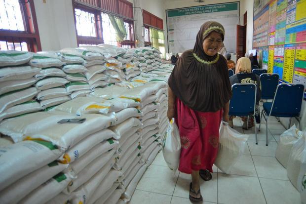 Warga membawa bantuan pangan beras di Kantor Lurah Purus, Padang, Sumatera Barat, Selasa (15/7/2025). Perum Bulog Wilayah Sumatera Barat menyalurkan bantuan pangan berupa beras10 kilogram dengan jumlah penerima sebanyak 339.290 penerima bantuan pangan periode Juni dan Juli 2025 yang tersebar 17 kabupaten/Kota di Sumbar.