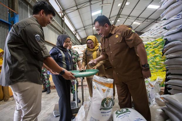 Petugas Dinas Ketahanan Pangan dan Pertanian (DKPP) kabupaten Indramayu bersama tim Satgas Pangan memeriksa kualitas beras bantuan pangan yang akan disalurkan di gudang Bulog Indramayu, Jawa Barat, Selasa (15/7/2025). Perum Bulog memastikan kesiapannya dalam menyalurkan bantuan pangan beras kepada 18,27 juta penerima bantuan pangan (PBP) di seluruh Indonesia untuk menjaga stabilitas ekonomi masyarakat berpenghasilan rendah dan menekan inflasi pangan.