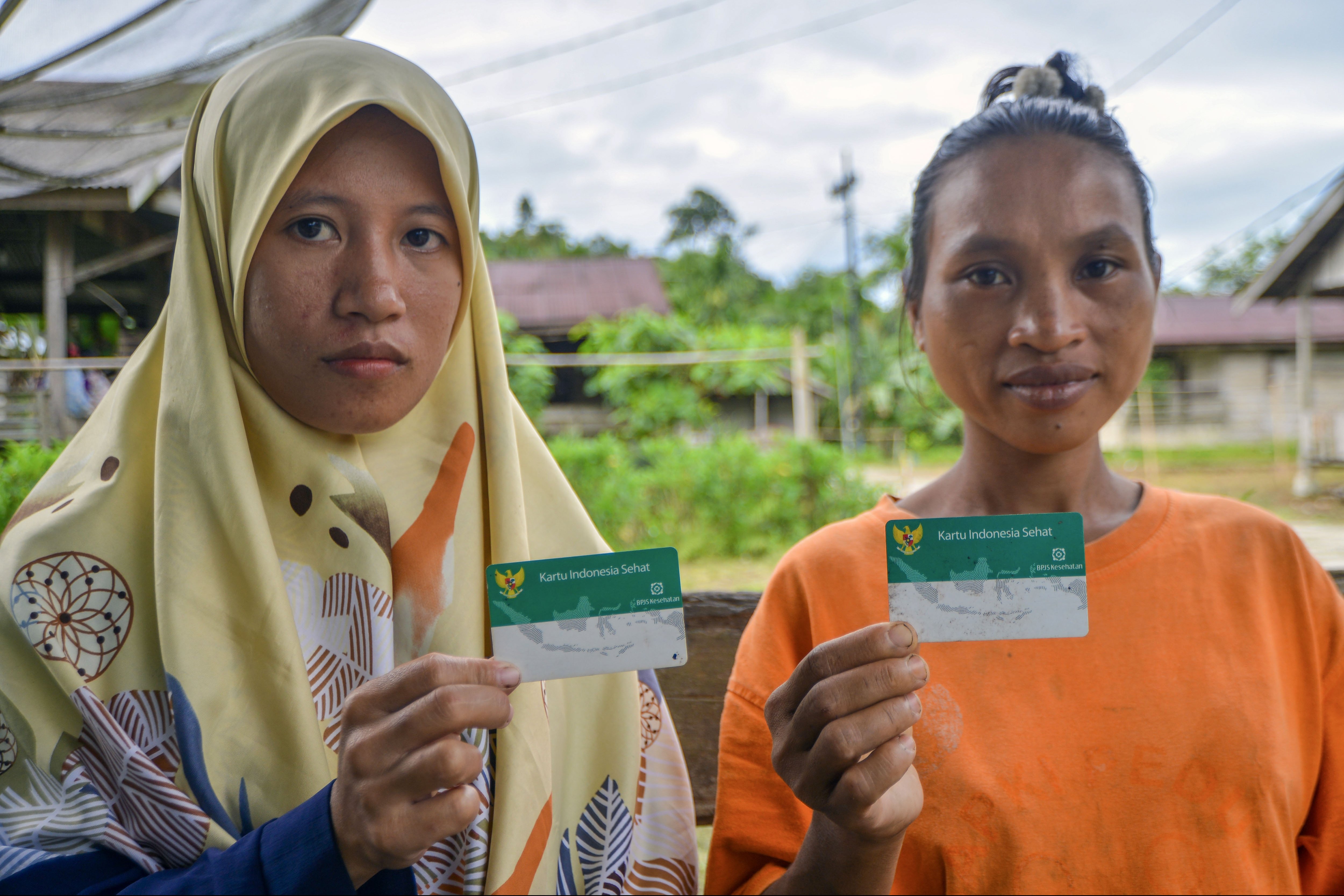 Dua warga menunjukan kartu BPJS Kesehatan sebelum berobat di Polindes Desa Matotonan, Siberut Selatan, Mentawai, Sumatera Barat.