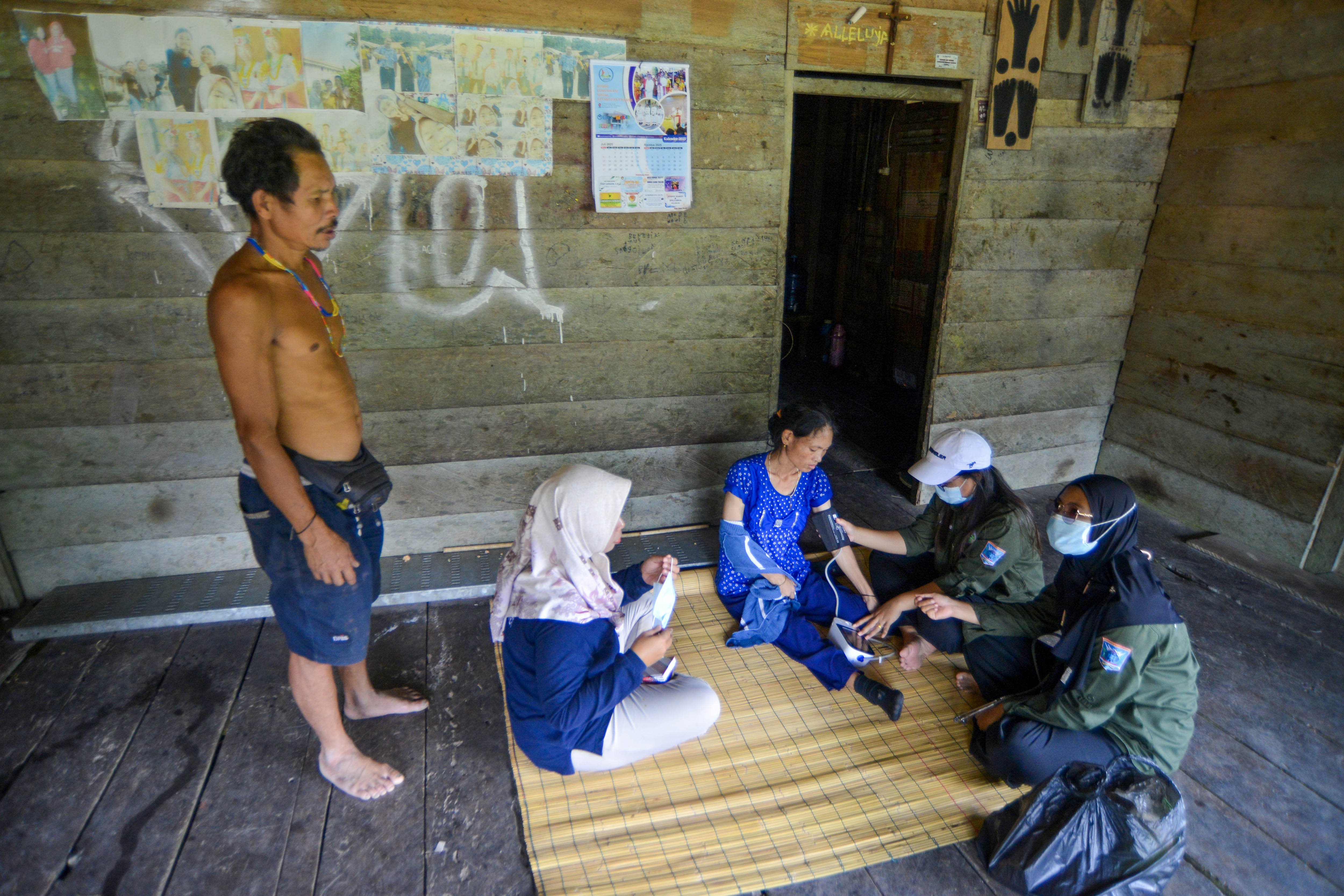 Dokter didampingi bidan memeriksa kondisi kesehatan warga di rumah di Dusun Matektek, Desa Matotonan, Siberut Selatan, Mentawai, Sumatera Barat.