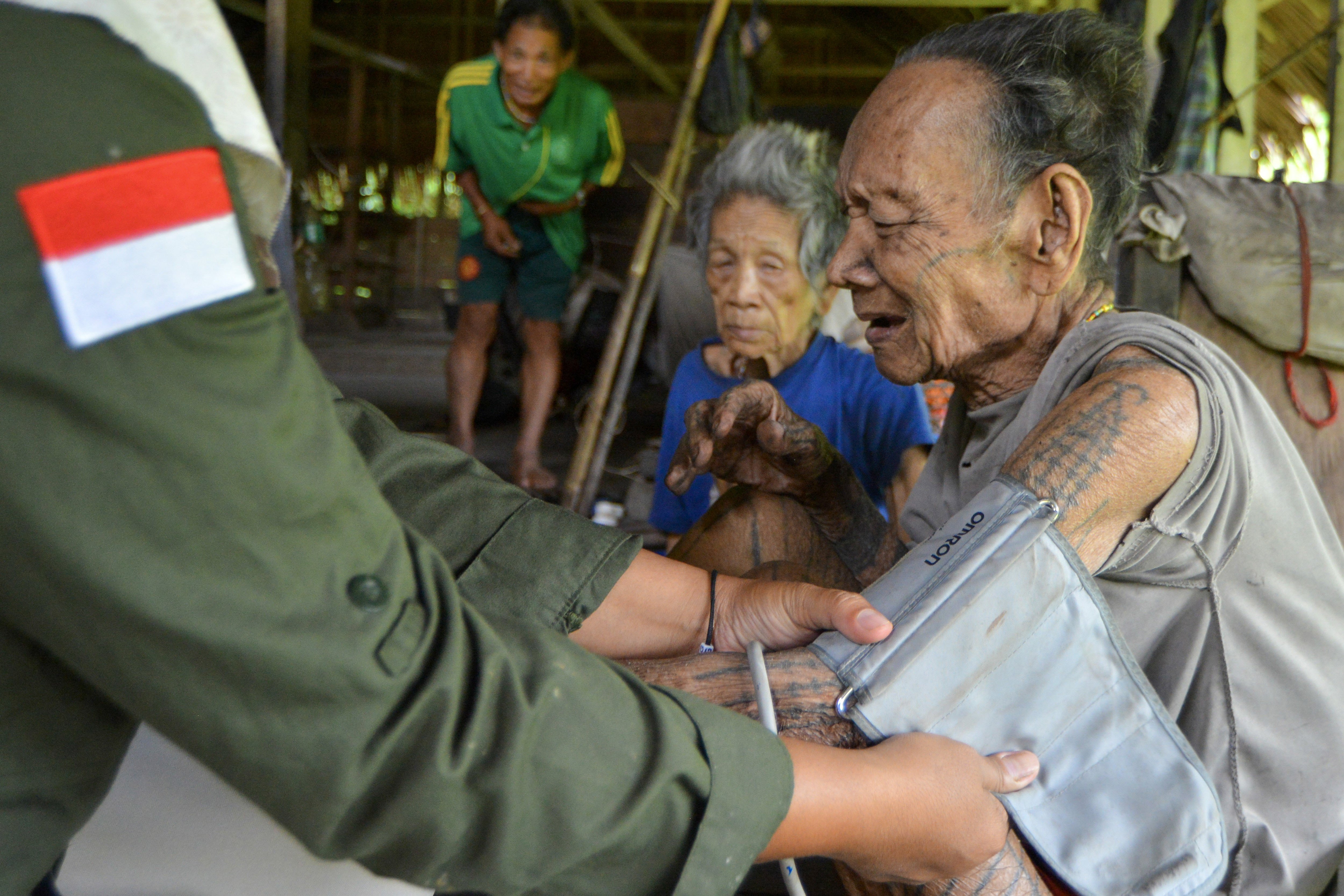 Bidan Ilen memeriksa kondisi kesehatan seorang Sikerei (dukun Mentawai) yang sakit di rumah di Dusun Matektek, Desa Matotonan, Siberut Selatan, Mentawai, Sumatera Barat.