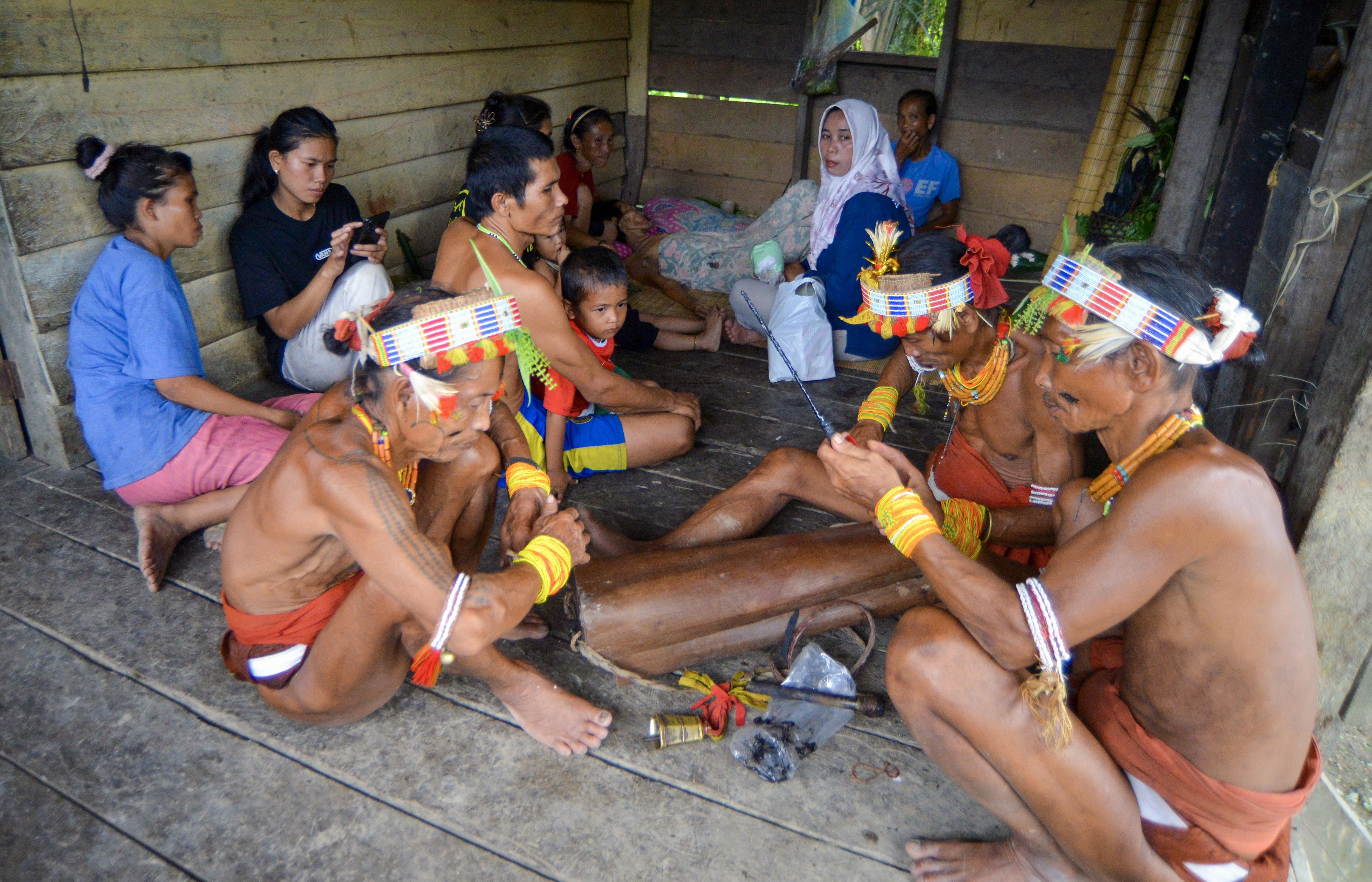 Bidan Ilen (tengah) berada di antara para Sikerei (dukun Mentawai) saat memeriksa kondisi warga di rumah di Dusun Matektek, Desa Matotonan, Siberut Selatan, Mentawai, Sumatera Barat.